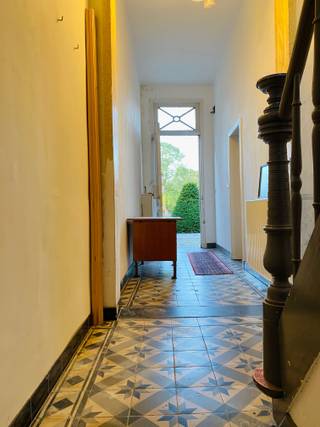 <br />In het hart van het idyllische Begijnhof van Turnhout, erkend als UNESCO Werelderfgoed, bevindt zich deze charmante en deels gerenoveerde woning in erfpacht. Een unieke kans voor wie houdt van historische architectuur, rust en een uitzonderlijk stukje erfgoed.<br />Bij binnenkomst word je verwelkomd door een brede gang die meteen het authentieke karakter van de woning benadrukt. Aansluitend vind je een ruime, gezellige woonkamer, waar de dubbele deuren zorgen voor een mooie lichtinval en directe toegang bieden tot het kleine, maar groene en intieme terras.<br />De ruime keuken vormt het hart van het gelijkvloers en biedt eveneens toegang tot het terras. Achter de keuken ligt een grote polyvalente ruimte met tal van mogelijkheden: atelier, hobbyruimte, thuiskantoor of extra leefruimte. Dankzij de hoogte kan hier zelfs een mezzanine worden ingericht. In deze ruimte bevinden zich ook een douche en lavabo, verder is er nog een apart toilet.<br />Op de bovenverdieping bevinden zich twee ruime slaapkamers en een te installeren badkamer. Alle materialen voor de plaatsing van een bad, lavabo en toilet zijn reeds aanwezig.<br />Tot slot beschikt de woning nog over een ruime, volledig te renoveren zolder die zich uitstekend leent voor extra bergruimte of een toekomstige uitbreiding.<br />Deze woning combineert historische charme met tal van mogelijkheden om er een comfortabele en persoonlijke thuis van te maken — allemaal op een werkelijk unieke, beschermde locatie.<br />Maandelijks te betalen kanon: 387 euro.