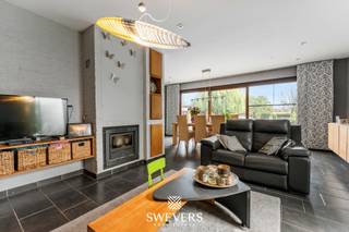 Voor meer info en foto’s, surf naar www.swevers.be – Ontdek deze uitzonderlijk ruime kangoeroewoning op een perceel van 19a 67ca in het gegeerde Kuringerheide, vlak bij Hasselt en natuurgebied De Platwijers. De woning werd gebouwd in 1980 en in 2006 functioneel omgevormd tot een volwaardige kangoeroewoning. Met een bewoonbare oppervlakte van 337 m², een gunstig EPC-label B en een praktische indeling is dit de ideale thuis voor grote gezinnen, inwonende familie of wie wonen en zorg wil combineren. De hoofdwoning beschikt over een lichtrijke leefruimte, keuken, bureau, slaapkamer en badkamer op het gelijkvloers. Op de verdieping bevinden zich meerdere slaapkamers, waardoor de woning in totaal zeven slaapkamers telt. Daarnaast zijn er drie badkamers aanwezig. De aparte woonunit beschikt over een eigen inkomhal, leefruimte met keuken, slaapkamer en badkamer, zodat privacy en zelfstandigheid verzekerd zijn. Onder de volledige woning bevindt zich een ruime kelder van 88 m², ideaal als opslag-, hobby- of werkruimte. Buiten geniet u van een dubbele carport, een zuidgerichte tuin en een heerlijk zwembad waar u in alle rust kan ontspannen. Airconditioning en rookdetectoren zorgen voor extra comfort. De woning biedt bovendien alle mogelijkheden om ze verder naar eigen smaak te moderniseren. Dankzij de rustige ligging bevinden scholen, winkels, openbaar vervoer en het centrum van Hasselt zich op korte afstand, terwijl ook de autosnelwegen vlot bereikbaar zijn. Een unieke eigendom met veel ruimte, flexibiliteit en toekomstmogelijkheden. Voor meer informatie, bel 011 255 155. Bron bewoonbare oppervlakte: EPC – verslag.