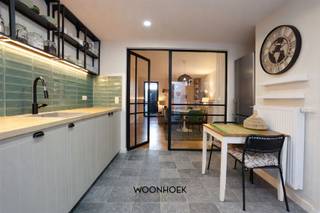 <p>Deze charmante woning combineert een serene uitstraling met een hoogwaardige afwerking in mediterrane stijl, energiezuinig wooncomfort en een doordachte indeling. Met een EPC-score van 152 kWh/m² biedt de woning een mooie balans tussen uitstraling, functionaliteit en energiezuinigheid. De open leefruimte, warme materiaalkeuzes en zonnige buitenruimte creëren een aangename woonomgeving waar u zich meteen thuis voelt.</p><hr /><p>Via de inkomhal bereikt u de lichtrijke leefruimte. De open indeling zorgt voor een aangenaam ruimtegevoel en biedt voldoende plaats voor een gezellige zit- en eethoek. Aansluitend bevindt zich de open keuken, waar functionaliteit en elegantie mooi samenkomen. Zo vormen koken, tafelen en ontspannen één harmonieus geheel.</p><p>Grote glaspartijen zorgen voor een aangename natuurlijke lichtinval en creëren een fijne verbinding tussen binnen en buiten. Vanuit de keuken heeft u rechtstreeks toegang tot de stadstuin, die een natuurlijk verlengstuk van de leefruimte vormt en een uitnodigende plek biedt om te genieten.</p><hr /><p>Op het gelijkvloers bevindt zich eveneens een praktische berging. Achteraan het perceel vindt u een afzonderlijk bijgebouw dat verschillende mogelijkheden biedt. Deze extra ruimte kan bijvoorbeeld worden ingericht als bureau, hobbyruimte of rustige thuiswerkplek. Zo kunnen wonen en werken comfortabel van elkaar worden gescheiden.</p><p>Op de eerste verdieping bevinden zich twee volwaardige slaapkamers. Dankzij de verzorgde afwerking bieden beide kamers een comfortabele plek om volledig tot rust te komen. Verder vindt u op deze verdieping de moderne badkamer, die mooi aansluit bij de stijlvolle uitstraling van de woning.</p><hr /><p>Ook op technisch vlak beschikt de woning over belangrijke troeven. Naast het EPC van 152 kWh/m² is de elektrische installatie conform gekeurd. Zo geniet u van een stijlvolle woonomgeving met hedendaags en energiezuinig wooncomfort.</p><p>De combinatie van de mediterrane uitstraling, twee slaapkamers, de zonnige stadstuin en het multifunctionele bijgebouw maakt deze woning bijzonder geschikt voor koppels, kleine gezinnen of thuiswerkers.</p><p>Plan uw bezoek eenvoudig online, telefonisch via 09 310 77 07 of mail naar info@woonhoekvastgoed.be</p>