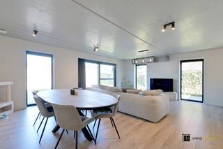<p><strong>Moderne, energiezuinige woning met tuin in rustige woonwijk</strong></p>
<p>Ideale gezinswoning voor wie modern, energiezuinig en zorgeloos wil wonen.<br /><br />In deze recente en instapklare woning (bouwjaar 2020 – eerste bewoning 2021) met een bewoonbare oppervlakte van ca. 160m² op een perceel van ca. 260m² geniet u van ruimte, licht en rust.<br />Gelegen op het einde van een doodlopende straat in een bijzonder rustige woonwijk, bevindt deze woning zich bovendien op wandelafstand van het centrum, horeca en openbaar vervoer.<br /><br />Gelijkvloers<br />De centrale inkomhal beschikt over de trap naar de bovenverdieping en gastentoilet. Verder door betreedt u een verzorgde en lichtrijke leefruimte, waar een combinatie van laminaat en beige vloertegels zorgt voor een warme en moderne uitstraling. De volledige benedenverdieping is uitgerust met vloerverwarming en strak afgewerkte, wit geschilderde muren met betonnen plafonds. <br />De open, volledig geïnstalleerde keuken met eiland biedt alle hedendaags comfort en is praktisch ingericht, onder meer met dubbele lades en kwalitatieve toestellen. Aansluitend bevindt zich een praktische berging/technische ruimte, dewelke uitgeeft op de oprit en ook terug uitkomt in de inkomhal. <br />Via een groot schuifraam met vliegenraam heeft u directe toegang tot het terras en de tuin, wat zorgt voor een vlotte overgang tussen binnen en buiten.<br /><br />Eerste verdieping<br />Op de eerste verdieping bevindt zich de nachthal die toegang biedt tot:<br />• 3 volwaardige slaapkamers, elk ruim en praktisch in te delen<br />• Een apart toilet <br />• Een badkamer voorzien van lavabo, inloopdouche en handdoekdroger met aansluitingen voor een tweede lavabo<br />De indeling maakt deze verdieping ideaal voor gezinnen of voor wie extra ruimte wenst voor bureau of hobby.<br /><br />Tuin & buitenruimte<br />De woning beschikt over een aangename, volledig omheinde tuin met terras, perfect georiënteerd voor ontspanning en buitenleven. Daarnaast is er een tuinhuis aanwezig. De oprit bevindt zich rechts van de woning en beschikt over een dubbele poort om de tuin te bereiken en ook laadpaal. <br /><br />Troeven<br />• Instapklaar en volledig geschilderde muren<br />• Energiezuinig o.a. dankzij zonnepanelen en airco’s in elke ruimte<br />• Regenwaterrecuperatie (toiletten, wasmachine en buitenkranen)<br />• Dubbele beglazing en kwalitatief PVC-schrijnwerk<br />• Verduistering aan de binnenzijde + vliegenramen<br />• Ventilatiesysteem D<br />• 2 toiletten <br /><br />Ligging<br />Rustig gelegen in een doodlopende straat binnen een woonwijk, met een uitstekende bereikbaarheid en nabijheid van winkels, scholen en openbaar vervoer.</p>