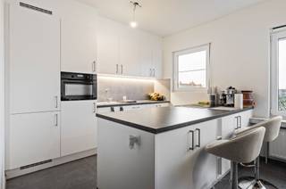 Welkom in dit stijlvol en tot in de puntjes vernieuwde appartement, gelegen op de tweede én bovenste verdieping van een kleinschalig gebouw. Dankzij die ligging geniet je hier van maximale rust en privacy, zonder bovenburen en met een groen uitzicht dat meteen voor ontspanning zorgt.<br /><br />Het appartement wordt momenteel verhuurd aan een betrouwbare huurder met een maandelijkse huurprijs van €1.050, wat zorgt voor een onmiddellijk rendement voor investeerders.<br /><br />De indeling is als volgt: een ruime inkomhal die uitkomt op de lichtrijke leefruimte van maar liefst 43 m², met een open en moderne keuken waar koken en leven perfect samenvloeien. De twee slaapkamers (13,5 m² en 10 m²) zijn volwaardig en rustig gelegen. De badkamer is uitgerust met een stijlvolle inloopdouche en lavabomeubel. Daarnaast is er een apart gastentoilet en een praktische berging.<br /><br />Het zuidgericht terras nodigt uit tot gezellige buiten momenten. En parkeren? Dat doe je zorgeloos in de garagebox, verplicht bij aan te kopen €25.000.<br /><br />De maandelijkse provisie bedraagt €184 (incl. gem. kosten, syndicus, poetsdienst, verwarming en water). Elektriciteit is via een individuele meter.<br /><br />Benieuwd om dit appartement te ontdekken? We plannen met plezier een bezoek in, contacteer Neon Vastgoed via 03/336.88.88 of mail naar info@neonvastgoed.be.