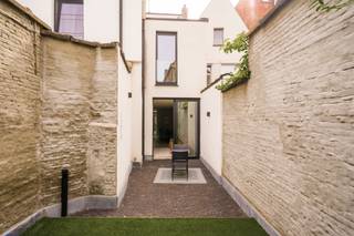 <p><strong>Quares - TREVI Groep presenteert :<br />Prachtige gerenoveerde lichtrijke woning </strong></p>
<p>Deze prachtige moderne stadswoning werd gerenoveerd in 2020. Hierbij werd er gewerkt met kwalitatieve en hoogwaardige materialen alsook werd er rekening gehouden met een optimale indeling van de ruimtes. Een enorm ruimtegevoel werd gecreëerd door grote raampartijen, een goede vormgeving en de juiste oriëntatie waarbij het behoud van authentieke elementen centraal staat. Er werd gewerkt met verschillende glazen vloeren die voor extra veel daglicht in de ruimtes zorgen, zowel op het gelijkvloers als op de verdiepingen.</p>
<p>Bij het betreden van het pand krijg je een instant wauw-gevoel door de hoge plafonds, warme materialen in combinatie met modern comfort. De leef- en eetruimte zijn volledig opengetrokken waarbij je een directe connectie ervaart met de achterliggende tuin. De leefkeuken is het centrale hart van de woning waar je een leuke interactie kan ervaren tussen koken, aperitieven, gezelligheid en wederom dezelfde connectie met de achterliggende tuin. Door het grote schuifraam kan je een binnen/buiten gevoel creëren waarbij bij zonnig weer deze ruimtes naadloos in elkaar overlopen.</p>
<p>Vooraan aan de woning is er een afzonderlijke ruimte voorzien die naar wens kan worden gebruikt als vestaire, maar ook als stallingsruimte voor fietsen. Verder is er nog een afzonderlijk gastentoilet.<br /><br />De woning werd maximaal voorzien van ingemaakte kasten met volledige inrichting voor een luchtige beleving van de woning. Deze zijn op elke verdieping terug te vinden.<br /><br />Via de trap kan je naar de eerste verdieping. Hier bevindt zich de master bedroom en een tweede slaapkamer. De prachtige badkamer is voorzien van een ligbad, dubbele lavabo en ruime inloopdouche met lichttherapie en regendouche en biedt het ultieme ontspanningsmoment. Naast de badkamer is er een afzonderlijk toilet. In de ingemaakte dressingkasten bevindt er zich aansluitingen voor wasmachine en droogkast (tevens aanwezig in kelder).</p>
<p>Op de tweede verdieping bevinden zich nog twee ruime slaapkamers alsook een volledig afzonderlijke open ruimte voor een bureau met twee werkplekken, ideaal voor thuiswerk zonder een slaapkamer te moeten opgeven.<br /><br />Eén van de slaapkamers kan ook omgevormd worden naar een (tweede) leefruimte indien gewenst. <br /><br />De tuin met terras is volledig aangekleed en gezellig ingericht, ideaal om te ontspannen in alle privacy. Daarnaast werd deze ook zeer onderhoudsvriendelijk ingericht. <br /><br />De kelderverdieping is volledig bruikbaar en leent zich ideaal voor een afzonderlijke speelruimte/leefruimte voor kindjes, een she shed of man cave.</p>
<p>Deze woning is ideaal voor mensen die van ruimte en modern comfort houden en de aanwezigheid van zeer veel natuurlijk daglicht in hun woning cruciaal vinden. Daarnaast heeft de woning een zeer lage EPC score en een aangenaam binnenklimaat.</p>
<p>De woning situeert zich in het hart van de stad, op wandelafstand van openbaar vervoer, winkels, sportfaciliteiten, allen op wandel-/fietsafstand.<br /><br />Laat deze unieke kans niet voorbij gaan.</p>