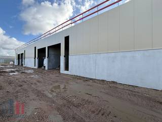 Gloednieuwe KMO-unit van 253 ² gelegen te Evergem. De unit maakt deel uit van het project 'Bizzpark Doornzele', een project gekenmerkt door duurzaamheid en architectuur. Er is bovendien een optie om een extra verdieping van 60 m² te realiseren, bespreekbaar op aanvraag, ideaal als kantoor of extra opslagruimte. Deze unit is uitgerust met een automatische sectionale poort en heeft een vrije hoogte van 6,5 meter. De unit is volledig geïsoleerd en afgewerkt met een duurzame polybetonvloer met een draagkracht van 2,5 ton/m² permanente belasting. De ruimte is ook voorzien van een lichtstraat met geïntegreerd rookluik, een elektrische aansluiting van 3 x 400V + N met een stroomsterkte van 40A. Elke unit beschikt tevens over een regenwaterput van 5.000 liter. Zonnepanelen kunnen nog optioneel worden voorzien, afhankelijk van de noden van de gebruiker. De omgeving van het gebouw wordt volledig aangelegd met groenvoorziening. Verplichte aankoop van één autostaanplaats, extra staanplaatsen mogelijk alsook mogelijkheid voor wachtbuizen voor het plaatsen van een laadpaal.<br /><br />De ligging in Evergem zorgt voor een uitstekende bereikbaarheid, op slechts 2 km van de R4, wat een vlotte verbinding biedt naar zowel de E34 richting Antwerpen/Knokke als de E40 richting Brussel en Oostende.<br /><br />Heeft u interesse of wenst u graag meer details over deze KMO-unit? Aarzel dan niet om contact op te nemen met PANORAMA B2B voor bijkomende informatie, gedetailleerde plannen of om een vrijblijvend plaatsbezoek in te plannen. U kunt ons bereiken op het nummer 0477 02 09 02.