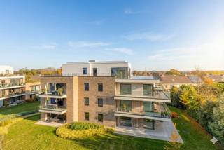 Bent u op zoek naar luxe, privacy en de vrijheid om uw eigen woonstijl te creëren? Dan is dit uitzonderlijke casco penthouse in het prestigieuze Domein Beverhof precies wat u zoekt. Het biedt een fantastisch woongevoel, zowel binnen als buiten.Dit exclusieve dakappartement (ca. 167 m²) wordt casco aangeboden, waardoor u niet gebonden bent aan standaardopties. U bepaalt zelf de volledige indeling en afwerking.U woont hier riant met een fenomenaal uitzicht dankzij het royale leefterras (ca. 100 m²) dat rondom het appartement loopt. Geniet in alle privacy van de zon en het omliggende groen. De leefruimtes sluiten mooi aan op het terras, wat een bijzonder ruimtelijk gevoel creëert.Indeling:- Ruime inkomhal met gastentoilet- Lichtrijke leefruimte met zit- en eethoek, uitkijkend op het terras- Mogelijkheid tot bureau of bibliotheek aansluitend op de woonkamer- Open keuken met plaats voor kookeiland en eethoek, met aanpalende ruime technische berging- Twee ruime slaapkamers, telkens met ruimte voor een en-suite badkamer- Praktische buitenberging op het terrasDit nieuwbouwpenthouse streeft naar een E-peil van E35 en wordt uitgerust met een warmtepomp en vloerverwarming. U woont hier niet alleen stijlvol, maar ook energiezuinig. Domein Beverhof staat bovendien voor absolute rust: drie elegante woonblokken in een aangelegde, omheinde tuin met automatische toegangspoort.Mogelijkheid om ruime ondergrondse garage bij aan te kopen.Wilt u dit penthouse naar uw eigen smaak inrichten? Contacteer ons voor een bezoek ter plaatse op de Beversesteenweg en ontdek alle mogelijkheden.