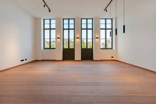 TREVI GENT: Luxe 2 slaapkamer appartement<br />Betreed een wereld van ongeëvenaarde luxe, gelegen in het kloppende hart van Gent, pal op de Vrijdagmarkt. Deze weelderige eerste verdieping van het historische 'Tooghuis' brengt tijdloze charme en moderne verfijning harmonieus samen. Stap in de lift die uitkomt in de riante woonkamer met een indrukwekkende plafondhoogte van maar liefst 3,80 meter. De prachtige houten vloer straalt warmte uit, terwijl het balkon u trakteert op een spectaculair uitzicht op het standbeeld van Jacob van Artevelde. De hypermoderne open keuken, compleet met hoogwaardige inbouwapparatuur en stijlvolle kasten, ademt pure klasse. Direct naast de keuken vindt u een afgesloten terras, perfect voor ongestoord genot. Achterin de woning wacht een luxueuze badkamer met inloopdouche op u, ontworpen om u te verwennen. Vervolgens zijn er de twee comfortabele slaapkamers. Vergeet niet de vloerverwarming en warmtepomp voor optimaal comfort. Dit exclusieve pand belooft niet alleen een ongeëvenaarde levensstijl, maar ook de unieke kans om deel uit te maken van de rijke geschiedenis en cultuur van Gent. Mis deze zeldzame gelegenheid niet om in alle luxe en comfort te wonen, omringd door de levendige sfeer van de Vrijdagmarkt. <br />Beschikbaar op 1 november<br />€1850 + €100 syndicale kosten