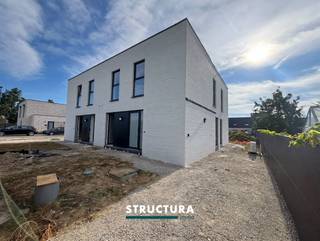 Nieuwbouwwoning met 3 slaapkamers en tuin gelegen in rustige, nieuwe wijk!Deze moderne nieuwbouwwoning, gelegen in het Kloppershof te Opwijk, combineert een hedendaagse architectuur met een stijlvolle afwerking en een praktische indeling. Dankzij de grote raampartijen geniet de woning van een overvloed aan natuurlijk licht en een aangename verbinding met de tuin.Op het gelijkvloers bevindt zich de inkomhal met vestiaire en afzonderlijk gastentoilet. De ruime leefruimte biedt plaats aan een gezellige zithoek en eetplaats en sluit naadloos aan op de moderne, open keuken met kookeiland. Via de grote raampartijen heeft u rechtstreeks toegang tot het terras en de tuin. Verder beschikt deze verdieping over een praktische wasberging.De eerste verdieping omvat drie slaapkamers en een ruime badkamer, uitgerust met zowel een ligbad als een inloopdouche en een dubbele wastafel. Daarnaast zijn er een afzonderlijk toilet en een extra berging aanwezig.Ook buiten biedt deze woning heel wat mogelijkheden. De tuin met terras vormt een aangename plek om te ontspannen, terwijl de carport (wordt nog geïnstalleerd) naast de woning voor extra gebruiksgemak zorgt.De woning bevindt zich momenteel in de laatste afwerkingsfase en zal binnenkort volledig klaar zijn voor haar eerste bewoners!Karakteristieken•Nieuwbouwwoning met hedendaagse architectuur•3 slaapkamers•Lichtrijke leefruimte met grote raampartijen•Moderne open keuken met kookeiland•Badkamer met ligbad, inloopdouche en dubbele wastafel•2 afzonderlijke toiletten•Praktische wasberging en extra berging•Tuin met terras•Parkeergelegenheid naast de woning onder carport•Verwarming via warmtepomp•ZonnepanelenEPB in opmaak. Onmiddellijk beschikbaar. 3 maanden huurwaarborg.