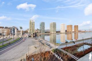 <strong>Lichtrijk BEN-appartement met open waterzicht in London Residence</strong><br /><br />Gelegen op de 2de verdieping van het recente en architecturaal verfijnde bouwproject “London Residence” bevindt zich dit stijlvol afgewerkte appartement met frontaal waterzicht en een aangename zuid-west oriëntatie.<br /><br />De leefruimte wordt gekenmerkt door haar rustige, tijdloze uitstraling, grote raampartijen voorzien van zonwerende screens en een mooie verbinding met de loggia. Het zicht op het water en de omliggende hedendaagse architectuur zorgt voor een open en ontspannen woongevoel, terwijl de zuid-west oriëntatie garant staat voor optimale lichtinval tot in de avond. Het appartement maakt deel uit van een kwalitatief woonproject met een verzorgde binnentuin, wat rust en privacy combineert met het bruisende karakter van het Eilandje.<br /><br /><strong>Indeling:</strong><br />- Inkomhal<br />- Apart gastentoilet met handenwasser<br />- Leefruimte en toegang tot de loggia van ca. 5,5 m² (zuid-west)<br />- Open keuken, afgewerkt met composiet werkblad en maatwerk, voorzien van kwalitatieve toestellen van Miele en Novy<br />- Praktische technische berging met ventilatiesysteem en aansluiting wasmachine en droogkast<br />- Verzorgde badkamer met ruime inloopdouche, dubbele lavabo met meubel<br />- Hoofdslaapkamer met ingebouwde kastenwand<br />- Tweede slaapkamer eveneens voorzien van ingebouwde kasten<br /><br /><strong>Bijzonderheden:</strong><br />- BEN-appartement met EPC-score E19 (28 kWh/m²/jaar)<br />- Vloerverwarming via gemeenschappelijke warmtepomp<br />- Gemeenschappelijke fietsenberging<br />- Mogelijkheid tot aankoop van staanplaats(en) onder het gebouw aan €35.000