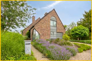 <strong>Immo Van Middelem verkoopt deze uitzonderlijk goed gelegen RUIME en LICHTRIJKE, INSTAPKLARE villa met 4 kamers, bureau, garage, terras en tuin op een perceel van +/- 4a82ca te St.-K.-Lombeek (Ternat).</strong><br /><strong>Winkels, scholen, openbaar vervoer, sportinfrastructuur, cultuurcentrum 'De Ploter',... bevinden zich allemaal op wandelafstand !</strong><br /><br />De achtertuin (gelegen langs de Beukstraat) werd intussen afgesplitst van de woning als bouwgrond voor een open bebouwing op +/- 4a01ca. Deze bouwgrond kan optioneel bijgekocht worden aan 210.000 €.<br /><br />De woning werd steeds zéér goed onderhouden, de eigenaars zijn doorheen de jaren blijven investeren in hun wooncomfort (zie document 'historiek woning' bij 'downloads').<br /><br />De indeling is als volgt: <br />- GELIJKVLOERS: inkomhal met WC en trap naar de 1ste verdieping, bureau met ingemaakte kasten, living (salon en eetplaats) met toegang tot de veranda en het terras, volledig geïnstalleerde keuken met eethoek en toegang tot het terras, berging;<br />- 1ste VERDIEPING: nachthal, WC, badkamer met bad en douche, 3 kamers waarvan 1 met dressing, 2 bergruimtes.<br />- ZOLDER 1 (via vaste trap): 1 kamer met doucheruimte en WC;<br />- ZOLDER 2 (via trapladder): bergzolder;<br />- GARAGE met stookplaats;<br /><br />Alarminstallatie.<br />CV op stookolie (aansluiting op stadsgas mogelijk).<br />8 zonnepanelen met thuisbatterij.<br />EPC: 240 kWh/m² - Label C (UC: 3585935).<br />Elektriciteit CONFORM tot 2050.<br />Asbestveilig.<br />Vrij bij akte.