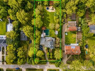 Verscholen in een oase van rust en groen, op een absolute toplocatie nabij het kasteel van ’s-Gravenwezel, bevindt zich deze charmante villa waar woonkwaliteit, privacy en natuurbeleving harmonieus samenkomen. Een eigendom waar men dagelijks geniet van rust en ruimte, zonder in te boeten aan bereikbaarheid. Scholen, openbaar vervoer en de centra van zowel ’s-Gravenwezel als Schilde bevinden zich op korte afstand, terwijl de omliggende groene omgeving een paradijs vormt voor wandel-, fiets- en sportliefhebbers.<br /><br />Via de automatische toegangspoort en stijlvolle oprijlaan bereikt u de woning, die u verwelkomt in een ruime centrale inkomhal. Van hieruit ontvouwt zich een warme en uitnodigende woonbeleving, gekenmerkt door lichtrijke ruimtes, een doordachte indeling en een voortdurende connectie met de prachtig aangelegde tuin.<br /><br />Aan de voorzijde bevindt zich de sfeervolle zithoek/tv-ruimte. Verder sluiten de eetkamer en bijkomende zithoek naadloos op elkaar aan, waardoor een bijzonder aangename leefomgeving ontstaat. Deze extra leefruimte leent zich perfect als salon, leeshoek of stijlvolle ontvangstruimte voor gasten.<br />De op maat gemaakte keuken met eiken kasten vormt samen met de omliggende leefruimtes het hart van de woning.<br /><br />Een bijzondere troef is het voortdurende zicht op de tuin en de zwemvijver. Vanuit vrijwel elke leefruimte geniet u van een prachtig groen panorama, waardoor binnen en buiten op een natuurlijke manier in elkaar overvloeien.<br /><br />Aansluitend bevindt zich een polyvalente ruimte die perfect kan ingericht worden als bureau, speelkamer of hobbyruimte. Daarnaast is er nog een extra kamer, momenteel ingericht als bureau, maar eveneens ideaal als slaapkamer op het gelijkvloers.<br /><br />Via de nachthal bereikt u nog twee slaapkamers en een tijdloze badkamer uitgerust met inloopdouche, toilet en lavabomeubel.<br /><br />Verder beschikt de woning over een extra ruimte ingericht als sportkamer, aansluitend aan de dubbele garage met elektrische poorten en de praktische wasplaats.<br />De verdieping omvat een riante master suite met ingemaakte kasten, elegant verwerkt in de schuine dakvlakken, en een badkamer ensuite.<br /><br />Ook buiten wordt u omringd door rust, charme en natuurbeleving. De prachtig aangelegde tuin met zwemvijver, drie terrassen en een sfeervol bijgebouw met buitenkeuken vormt een uitzonderlijke plek om te ontspannen, gasten te ontvangen of simpelweg te genieten van de stilte en het groen rondom u.<br /><br />Tot slot beschikt de woning nog over een kelderruimte en een kruipruimte onder het achterste gedeelte van de woning.<br /><br /><strong>Bijzonderheden</strong><br />+ Uitzonderlijke toplocatie nabij het kasteel van ’s-Gravenwezel<br />+ Perceel van ca. 2.915 m²<br />+ 4 slaapkamers en 2 badkamers<br />+ Zwemvijver en sfeervol bijgebouw met buitenkeuken<br />+ Dubbele garage met elektrische poorten<br />+ Oase van rust en groen met uitstekende bereikbaarheid<br />+ EPC E, mits aanpassing van ketel en houtkachel herleidbaar naar EPC D<br /><span>bew. opp. volgens EPC</span>