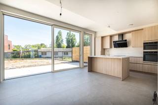 <p><strong>Instapklare nieuwbouwwoning met 5 slaapkamers in Oostmalle</strong><br /><br />Deze <strong>ruime</strong> en <strong>praktisch ingedeelde nieuwbouwwoning</strong> in <strong>Oostmalle</strong> biedt alles wat een modern gezin zoekt: <strong>royale leefruimtes</strong>, <strong>vijf slaapkamers</strong> en een <strong>hoogwaardige afwerking</strong> tot in de puntjes.</p>
<p>Bij het binnenkomen word je verwelkomd in een <strong>ruime inkomhal</strong> met een <strong>apart gastentoilet</strong>. Van daaruit kom je in de <strong>lichtrijke open leefruimte</strong> met <strong>eetkamer en keuken</strong>, die dankzij de <strong>grote raampartijen</strong> een mooie verbinding maakt met de <strong>tuin</strong>. Aansluitend bevindt zich een handige <strong>bijkeuken</strong>, met directe toegang tot de <strong>inpandige garage, </strong>ideaal voor <strong>extra opslag</strong> en comfort.</p>
<p>Op de eerste verdieping bevinden zich <strong>drie volwaardige slaapkamers</strong>, waarvan één beschikt over een aangrenzende <strong>dressing</strong>. Verder is er een <strong>ruime, stijlvolle badkamer</strong> voorzien van zowel een <strong>inloopdouche</strong> als een <strong>ligbad</strong>. Ook hier is een <strong>apart toilet</strong> aanwezig op de nachthal, wat extra praktisch is voor een gezin.</p>
<p>De tweede verdieping biedt nog meer ruimte met een <strong>zeer grote vierde slaapkamer</strong> en een <strong>extra kamer</strong> die perfect kan dienen als <strong>vijfde slaapkamer</strong>, <strong>bureau</strong> of <strong>hobbyruimte</strong>. Daarnaast is er een <strong>technische ruimte/zolderberging</strong> voorzien.</p>
<p>Met in totaal <strong>vijf slaapkamers</strong>, een <strong>dressing</strong>, <strong>inpandige garage</strong> en een <strong>slimme indeling</strong> over drie verdiepingen, is dit een woning met <strong>enorm veel potentieel</strong> voor wie op zoek is naar <strong>ruimte</strong>, <strong>comfort</strong> en <strong>kwalitatief wonen</strong>.</p>