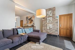 Voor meer info en foto’s, surf naar www.swevers.be – Deze ruime halfopen bebouwing aan de Motstraat 12 in Beringen combineert een rustige ligging met een vlotte bereikbaarheid nabij het centrum. Met een bewoonbare oppervlakte van 252 m² op een perceel van 561 m² biedt deze woning tal van mogelijkheden voor gezinnen, zelfstandigen of wie wonen en werken wil combineren. Op het gelijkvloers verwelkomt de inkomhal u in de gezellige woonkamer, gevolgd door een ruime keuken die het centrale hart van de woning vormt. Verder vindt u hier een badkamer met ligbad, wc, een douche en een wasplaats. Er is op deze verdieping nog een apart toilet, een slaapkamer en een veelzijdige hobbyruimte die perfect kan dienen voor een zelfstandige activiteit of extra leefruimte. Bovendien zijn er interessante uitbreidingsmogelijkheden aanwezig. De eerste verdieping van het hoofdgebouw beschikt over twee ruime slaapkamers en de eerste verdieping van de bijbouw beschikt over twee grote hobbykamers die eenvoudig kunnen worden ingericht als extra slaapkamers, bureau, speelkamer of hobbyruimte. Een afzonderlijk toilet zorgt ook hier voor extra comfort. Via een vaste trap in het hoofdgebouw bereikt u de ruime zolder van circa 39 m², ideaal als bergruimte of voor verdere invulling naar wens. Buiten geniet u van een aangename tuin met noordoostelijke oriëntatie waar rust, privacy en ontspanning centraal staan. De carport van 22 m² vormt een bijkomende troef. De ligging is bijzonder praktisch met winkels, openbaar vervoer en scholen op wandelafstand. Ook ontspanningsmogelijkheden en de snelweg bevinden zich vlakbij, wat zorgt voor een uitstekende bereikbaarheid. Deze karaktervolle woning biedt veel ruimte, flexibiliteit en toekomstpotentieel dankzij de combinatie van woonruimte, hobbykamers, handelsruimte, garage en uitbreidingsmogelijkheden. Voor meer informatie, bel 011 255 155. Bron bewoonbare oppervlakte: EPC – verslag. Dit pand is onderworpen aan de renovatieverplichting van de Vlaamse overheid voor residentiële gebouwen (behoudens bij sloop binnen 5 jaar na de aankoop). Consulteer voor meer informatie de website van het Vlaams Energie- en Klimaatagentschap via https://www.vlaanderen.be/een-huis-of-appartement-kopen/renovatieverplichting-voor-residentiele-gebouwen.