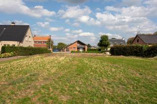 <p>Ontdek deze mooie bouwgrond voor een halfopen bebouwing. Het perceel laat een ruime gezinswoning toe met een bouwvolume van maximaal 9 x 15 m op het gelijkvloers en 9 x 13 m op de verdieping, aangevuld met een tweede bouwlaag onder het dak. Zowel een moderne woning met plat dak als een klassieke uitvoering met hellend dak zijn mogelijk, met een maximale nokhoogte van 11 m en kroonlijsthoogte van 6,50 m. Een gekoppelde oprit met inpandige garage is verplicht, terwijl achteraan een vrijstaand bijgebouw tot 40 m² kan worden opgericht. De totale verhardingsoppervlakte op het perceel is beperkt tot 70 m², waardoor het groene karakter optimaal behouden blijft. Een unieke kans om uw droomwoning te realiseren op een centrum locatie met uitzicht op een achterliggend weiland.</p>