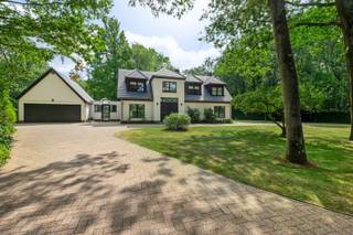 <p><span>Deze ruime villa (372m²) op een prachtig groen perceel (3.174m²) combineert een aangename architectuur met veel lichtinval en een uitzonderlijk veelzijdige indeling.</span></p><p><span>Een ideale thuis voor wie ruimte, privacy en groen weet te waarderen.</span></p><p><span>Via de ruime inkomhal met open trap betreden we de woning. Deze geeft ons vervolgens toegang tot de lichtrijke leefruimte. Deze geniet dankzij de grote raampartijen van een mooie verbinding met de tuin en biedt alle ruimte voor een gezellige zit- en eetkamer. De houthaard is hier ook een garantie voor gezellige en vooral warme winteravonden!</span></p><p><span>Aansluitend aan de leefruimte bevindt zich de open ingerichte keuken, welke is voorzien van meer dan voldoende werkblad- en kastruimte en de volgende toestellen: kookplaat, dampkap, vaatwasser, spoelbak, oven, combioven (microgolf - oven) en koelkast. Verder vinden we hier ook nog een verscholen koffiecorner en een aangename ontbijthoek met een prachtig zicht over de tuin (met zwembad). Naast de keuken bevindt zich nog een praktische en bijzonder ruime bijkeuken. Hier vinden we nog extra bergruimte, een microgolfoven en ook de voorzieningen voor wasmachine en droogkast.</span></p><p><span>Een absolute troef is de gelijkvloerse slaapvleugel. De ruime master charmeert met haar hoge plafond, karaktervolle schouw en rechtstreeks contact met de tuin (met vijver). Aansluitend bevinden zich een ingerichte dressing en een stijlvol vernieuwde badkamer met ligbad, ruime inloopdouche, dubbel lavabomeubel en toilet.</span></p><p><span>Verder vinden we op het gelijkvloers ook nog een tweede inkom, alwaar we het gastentoilet vinden en de toegang naar een extra berging. Hier vinden we ook de trap naar de kelderruimte, welke U ook nog heel wat bergruimte biedt.</span></p><p><span>Ook op de verdieping blijven ruimte en licht het sleutelwoord. Hier komen we allereerst bij een bijzonder lichtrijke, ruime bureauruimte met een prachtig zicht op het omliggende groen. Verder vinden we hier ook nog twee slaapkamers en een tweede volwaardige badkamer terug. Deze laatste is voorzien van een ligbad, douche, dubbel lavabomeubel en toilet.</span></p><p><span>Aan parkeergelegenheid op eigen terrein geen gebrek. Niet alleen beschikt de woning over een dubbele garage, ook op de ruime oprit kan men de nodige wagens kwijt.</span></p><p><span>Buiten geniet men van een volwassen, groene tuin die de woning ontzettend veel privacy en een heerlijk gevoel van rust geeft. In de tuin vinden we naast verscheidene gezellige terrassen ook een zwembad en een vijver terug, net als de nodige tuinbergingen en de technische ruimte van het zwembad.</span></p><p><span>Kortom, een verrassend ruim eigendom waar wonen, thuiswerken en ontspannen moeiteloos samengaan. Een unieke opportuniteit voor wie ruim en groen wil wonen!</span></p><p><span>Is uw interesse gewekt? We, dan hoor ik graag van U.</span></p>