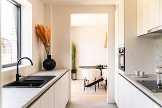 Deze moderne nieuwbouwwoning in De Kom in Leopoldsburg bevindt zich op een rustige ligging vlakbij de jachthaven, met aangename zichten op het water en een open, groen karakter.<br /><br />Met een bewoonbare oppervlakte van ca. 175 m² beschikt de woning over een ruime en lichtrijke leefruimte met open keuken, drie volwaardige slaapkamers en een nette badkamer. Dankzij de grote raampartijen geniet u van een mooie lichtinval en een directe connectie met het terras en de tuin van 23,51 m², ideaal om in alle rust te ontspannen.<br /><br />De woning is afgewerkt met kwalitatieve, moderne materialen en werd energiezuinig gebouwd, wat zorgt voor hedendaags comfort en een duurzaam karakter. In combinatie met de vlotte bereikbaarheid en de nabijheid van winkels, scholen en ontspanning, maakt dit deze woning bijzonder geschikt voor wie op zoek is naar instapklaar wooncomfort op een aangename locatie aan het water.