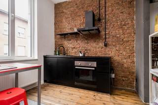 <p>In een kleinschalig gebouw met slechts vier appartementen bevindt zich dit appartement op de eerste verdieping. Via de gemeenschappelijke inkomhal bereik je het appartement.</p>
<p>Je betreedt meteen de leefruimte. Aan de voorzijde bevindt zich een praktisch keukentje dat, mits een kleine opfrissing, volledig naar eigen smaak kan worden ingericht.</p>
<p>Aansluitend aan de leefruimte bevindt zich een hal die toegang biedt tot de badkamer met inloopdouche. De slaapkamer ligt achteraan in het appartement en zorgt voor de nodige rust en privacy.</p>
<p>Dit appartement heeft wat liefde en vernieuwing nodig, maar biedt daardoor de perfecte kans om er een sfeervol en eigentijds thuis van te maken. Ideaal voor wie op zoek is naar een gezellig stadsappartement met potentieel!</p>