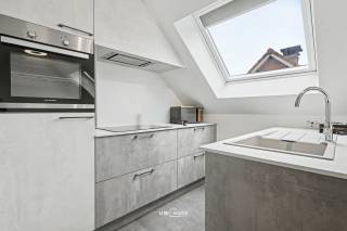Dit nieuwbouwappartement uit 2022 is gelegen op de tweede verdieping en biedt een prachtig uitzicht op de groene omgeving van de Roomkouter. Met een bewoonbare oppervlakte van 74 m² geniet u hier van moderne woonruimte met veel lichtinval en een comfortabele indeling.<br /><br />Het appartement beschikt over een open leefruimte en keuken met prachtig uitzicht, een badkamer die is voorzien van toilet, inloopdouche en enkele lavabo, twee ruime slaapkamers en een aparte berging. Daarnaast is er een parkeerplaats inbegrepen, wat het dagelijks parkeren zeer gemakkelijk maakt.<br /><br />Bovendien behoort een aparte ondergrondse berging tot het pand, zodat u voldoende extra opbergruimte hebt. Dit maakt het appartement niet alleen mooi en praktisch, maar ook perfect afgestemd op uw woonwensen in het mooie Steendorp.<br /><br />Het appartement kan, indien gewenst, ook aangekocht worden inclusief de aanwezige meubels, waardoor u meteen zorgeloos kunt intrekken.<br /><br />Hebt u interesse? Contacteer ons via info@uw-huis.be