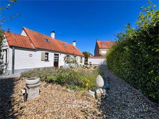 In de rustige Hostenstraat, verscholen in een groene en residentiële omgeving, vind je dit charmante vissershuis dat meteen een gevoel van geborgenheid oproept. Het is een woning met karakter en ziel, waar de traditie van de kust perfect samenkomt met hedendaags comfort. Hier woon je niet in de drukte van de zeedijk, maar geniet je van een sereen dorpsgevoel, met toch alles vlakbij.<br />De woning werd grondig vernieuwd in 2005 en is met veel zorg onderhouden, waardoor ze instapklaar is voor wie meteen wil verhuizen of er een gezellig vakantieverblijf van wil maken. Dankzij de aanwezigheid van een ruime garage, meerdere slaapkamers en een tuin biedt dit huis verrassend veel mogelijkheden, zowel voor jonge gezinnen als voor koppels die kiezen voor een comfortabeler leven aan zee.<br />De leefruimte straalt warmte en authenticiteit uit, met details die herinneren aan de klassieke kuststijl. Tegelijk geniet je van een praktische indeling die het dagelijks leven vergemakkelijkt. Een extra troef is dat wonen op het gelijkvloers perfect mogelijk is, wat het huis toegankelijk maakt voor alle generaties. De tuin vormt een oase van rust: een plek waar kinderen kunnen spelen, waar je met vrienden kan aperitieven of waar je simpelweg tot rust komt in de buitenlucht.<br />De ligging van dit vissershuis is een absolute meerwaarde. Je woont in een rustige straat zonder doorgaand verkeer, maar toch op wandel- en fietsafstand van winkels, horeca, sportfaciliteiten en openbaar vervoer. Het strand en de duinen zijn makkelijk bereikbaar, waardoor je in een oogwenk kan genieten van een lange strandwandeling of een dagje zee. Ook de E40 ligt vlakbij, wat zorgt voor een uitstekende verbinding naar de rest van de kust en het binnenland.<br />Dit vissershuis is ideaal voor wie zoekt naar authenticiteit, rust en een warme thuisbasis. Of je nu droomt van een vaste woonst met karakter, een tweede verblijf waar je met volle teugen kan genieten, of een investering in een woning met ziel – hier voel je dat elke steen een verhaal vertelt.<br /><br /><br />Benieuwd of dit jouw nieuwe thuis kan worden? Bel ons vandaag nog voor een bezoek en laat je betoveren door de charme van dit unieke vissershuis in Koksijde.<br />Vg-Wg-Gmo-Gvkr-Gvv-EPC : 809 kWh/m2 (Label F – Renovatieplicht)<br />Waterinfo : P-Score = A, G-Score = A<br /><br />Dit is niet wat je zoekt ? Al gehoord van AANKOOPBEGELEIDING ? Wij zoeken, bezoeken en onderhandelen mee met jou voor eigendommen die worden aangeboden door particulieren, andere makelaars of eigendommen die zelfs (nog) niet te koop staan?<br />Vraag meer informatie over aankoopbegeleiding via welkom@dehuisleverancier.be of 0489/069.000<br /><br />de Huisleverancier : Persoonlijk, voor iedereen Service, Kwaliteit en Vertrouwen !