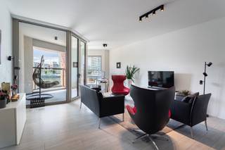 <p>Op het Eilandje, op één van de meest idyllische locaties van Antwerpen met een prachtig zicht over de water met de Londenbrug, bevindt zich dit gezellig en zeer smaakvol afgewerkt appartement van ca 108 m² in de 'New York Residence'. Vanop de New Yorkkaai kan u ongestoord genieten van de bootjes die de jachthaven binnenvaren. Bovendien is een goede bereikbaarheid gegarandeerd door de nabijheid van tal van invalswegen. De wandelboulevard zorgt voor een gezellige sfeer.</p>
<p>De inkomhal leidt naar een ruime leefruimte waar wonen en genieten samenvloeien. Het aansluitende overdekte terras van ca 7 m² aan de voorzijde is een verlengstuk van de leefruimte en vormt de ideale plek om van het frontaal zich op het water te genieten. De doorzon leefruimte geniet langs twee kanten van een mooie lichtinval. Aan de achterzijde bevindt zich de open, moderne keuken welke volledig is uitgerust met oven, inductievuur, koelkast met vriesvak en vaatwasser. Van hieruit heeft u toegang tot het tweede terras van ca 19 m² welke uitkijkt op de groene binnentuin van de residentie.</p>
<p>De hoofdslaapkamer is mooi ruim en biedt voldoende plaats voor een grote dressingkast. De tweede slaapkamer is ideaal te gebruiken als kinderkamer of bureau. Ze kunnen gebruikmaken van de badkamer met ruime inloopdouche en dubbele lavabo.</p>
<p>Apart gastentoilet en berging met aansluiting voor wasmachine en droogkast.</p>
<p>De grote troef van dit appartement is ongetwijfeld het fantastische gemeenschappelijke dakterras waar u de hele dag door kan genieten van de zon en het uitzicht.</p>
<p>Deze ligging op het Eilandje combineert het beste van twee werelden: de rust en ruimte van het water, gecombineerd met de nabijheid van gezellige cafeetjes, restaurants en het bruisende centrum van Antwerpen.</p>
<p>Praktische gemeenschappelijke fietsenstalling.</p>
<p>Mogelijkheid tot aankoop van ondergrondse autostaanplaats aan 40.000 Euro, excl. registratiebelasting.</p>