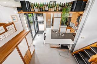 <h1><span>Exclusieve architectenwoning met binnen- en buitenzwembad op toplocatie in Mortsel</span></h1><p><span>Deze uitzonderlijke architectenwoning, gelegen in een gegeerde residentiële wijk nabij het Park van Mortsel, combineert tijdloze architectuur met design, functionaliteit en een uitzonderlijk wooncomfort. Een unieke eigendom voor wie op zoek is naar ruimte, licht, privacy en karakter.</span></p><p><span>De ligging vormt een absolute meerwaarde: rustig en groen, terwijl scholen, winkels, openbaar vervoer en tal van ontspanningsmogelijkheden zich op wandelafstand bevinden.</span><span><br /><br /></span></p><h2><span>Een bekroond architecturaal concept</span></h2><p><span>Deze bijzondere woning werd ontworpen door architect </span><span>Lou Jansen</span><span>, die voor dit ontwerp de </span><span>tweede prijs van de Robert Maskens-prijs (1980)</span><span> ontving. De realisatie is het resultaat van een succesvolle samenwerking met interieurarchitect </span><span>Adri Hazebroek</span><span>, waarbij architectuur en interieur naadloos in elkaar overvloeien.</span></p><p><span>De woning werd in de lengte gebouwd en harmonieus geïntegreerd in de prachtig aangelegde tuin, die zich uitstrekt over twee percelen met een totale oppervlakte van ongeveer </span><span>950 m²</span><span>.</span></p><p><span>De solide metalen draagstructuur met een welbepaald ritme van voor- tot achteraan de woning bepaalt de verschillende leefruimtes. Zowel de individuele ruimtes als de gemeenschappelijke zones vormen samen één visueel doorlopend geheel, waarbij licht, ruimte en groen centraal staan.</span></p><h1><span>Indeling</span></h1><h2><span>Gelijkvloers  </span></h2><p><span>De volledig uitgeruste leefkeuken vormt zonder twijfel het hart van de woning. Vanuit de keuken geniet u van een directe toegang tot het terras en de tuin, terwijl het open ontwerp voortdurend contact houdt met de verschillende leefruimtes.</span></p><p><span>De keuken werd tot in de kleinste details doordacht. Hoogwaardige materialen en kwalitatieve toestellen zorgen voor optimaal gebruiksgemak, waaronder een inductiekookplaat, vaatwasser, oven, warmhoudlade, microgolfoven, dubbele spoelbak, ingebouwde friteuse en een duurzaam werkblad in roestvrij staal. Zelfs praktische details, zoals een discreet geïntegreerd opstapje voor de hoge kasten, werden zorgvuldig uitgewerkt.</span></p><p><span>Aansluitend bevindt zich een praktische hal met vestiaire, die rechtstreeks toegang geeft tot de wasplaats, de dubbele inpandige garage en de inkomhal. Ook de ruime kelder is vanuit de keuken gemakkelijk bereikbaar.</span></p><p><span>De kelderverdieping biedt bijzonder veel bergruimte en huisvest alle technische installaties van de woning. Daarnaast beschikt de woning over een sfeervolle, professioneel ingerichte wijnkelder waar uw wijncollectie onder ideale omstandigheden kan worden bewaard.</span></p><h2><span>Leefniveau</span></h2><p><span>Via een korte trap bereikt u het centrale leefniveau, waar de architecturale kwaliteiten van deze woning volledig tot hun recht komen. De leefruimtes openen zich naar de tuin en genieten dankzij de grote glaspartijen van een overvloed aan natuurlijk licht.</span></p><p><span>De lichtrijke eetkamer vormt het centrale punt van deze verdieping en wordt langs de zijkant volledig omringd door groen. Aansluitend bevindt zich een eerste elegant salon met een prachtig zicht op de aangelegde tuin, de terrassen en het zwembad. Deze ruimte is ideaal om gasten te ontvangen of in alle rust te genieten van een aperitief, terwijl de groene omgeving een unieke, zuiderse sfeer creëert.</span></p><p><span>Verder op het leefniveau bevindt zich een tweede, meer intieme zithoek met een gezellige open haard. Deze tv- en familieruimte sluit naadloos aan op de bureauruimte, die jarenlang dienstdeed als bureau- en ontvangstruimte. Vandaag biedt deze veelzijdige ruimte tal van mogelijkheden als thuiskantoor, speelruimte of extra leefruimte. Dankzij de afsluitbare indeling geniet u hier van een perfecte balans tussen verbondenheid en privacy.</span></p><h2><span>Nachtniveau</span></h2><p><span>De masterbedroom bevindt zich op een afzonderlijk niveau van de woning en vormt een volledig private suite.</span></p><p><span>Deze ruime slaapkamer beschikt over een praktische dressing en een luxueuze en-suite badkamer, uitgerust met een bubbelbad, een ruime inloopdouche en een stijlvol lavabomeubel.</span></p><p><span>Aansluitend bevindt zich een gezellig privéterras waar u in alle rust kunt genieten van een koffie in de ochtend of een ontspannen avond met zicht op het omliggende groen.</span></p><p><span>Vanuit dit niveau heeft u bovendien toegang tot de wellnessruimte met sauna, fitnessruimte en het verwarmde binnenzwembad dat naadloos overloopt in het buitenzwembad.</span></p><h2><span>Bovenste verdieping</span></h2><p><span>Op de bovenste verdieping bevinden zich twee volwaardige slaapkamers, een aparte gastenkamer en een tweede badkamer.</span></p><p><span>De tweede badkamer is praktisch ingericht met een douche en een stijlvol lavabomeubel en vormt een aangename meerwaarde voor de slaapkamers en eventuele gasten.</span></p><p><span>De gastenkamer beschikt over een extra zitruimte in de nok van de woning. Dankzij de bijzondere lichtinval is dit een ideale plek om rustig te lezen, te ontspannen of te genieten van een moment voor uzelf. De architecturale vormgeving van de nok zorgt hier voor een bijzonder sfeervolle ruimte met karakter.</span></p><h2><span>Buitenleven</span></h2><p><span>ook buiten werd niets aan het toeval overgelaten.</span></p><p><span>de fraai aangelegde tuin beschikt over meerdere zonneterrassen, een verwarmd binnen- en buitenzwembad en een prachtige groene pergola achteraan het perceel, waardoor u zich meteen in zuid-frankrijk waant.</span></p><p><span>een ruime tuinberging biedt voldoende plaats voor al het tuinmateriaal. de tuin werd bovendien bijzonder verzorgd aangelegd en is dankzij de doordachte inrichting aangenaam te onderhouden.</span></p><p><span>een extra troef is het tweede perceel achteraan de woning, dat bereikbaar is via zowel de lusthovenlaan als de vernieuwde edmond thieffrylaan. het achterste gedeelte van het perceel ligt bovendien op bouwgrond, wat extra potentieel biedt.</span></p><h2><span>Comfort en technieken</span></h2><p><span>doorheen de jaren werd de woning voortdurend gemoderniseerd met bijzondere aandacht voor kwaliteit, duurzaamheid en energiezuinigheid. dit resulteert in een gunstig epc-label b.</span></p><p><span>De woning beschikt onder meer over:</span></p><ul><li><span>Zonnepanelen</span></li><li><span>Vloerverwarming</span></li><li><span>Airconditioning</span></li><li><span>Luchtverwarming gestuurd door een recente gasketel</span></li><li><span>Gedeeltelijk zonwerend glas</span></li><li><span>Glass Heating</span><span>-</span><span>beglazing op geselecteerde ramen</span></li><li><span>Verwarmd binnen- en buitenzwembad met warmtepomp</span></li><li><span>Dubbele inpandige garage</span></li><li><span>Ruime kelder en wijnkelder</span></li></ul><h2><span>Een unieke woonbeleving</span></h2><p><span>Deze uitzonderlijke architectenwoning combineert bekroonde architectuur met hedendaags comfort, hoogwaardige afwerking en een unieke beleving van binnen- en buitenruimte.</span></p><p><span>Een zeldzame opportuniteit voor wie op zoek is naar een exclusieve woning op een toplocatie in Mortsel, waar kwaliteit, ruimte, natuur en luxe perfect samenkomen</span><span>.</span></p><p><span>Deze woning kan verkocht worden onder aandelenportefeuille en is inclusief 4 garageboxen in de nabije omgeving die verhuurd zijn.</span></p><p><span>Deze woning moet u voelen en beleven. Maak vlug een afspraak op <span>www.coprimmo.be</span></span><span> of 03/449.49.77</span></p><p><span> </span></p>