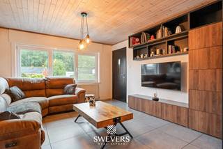 Voor meer info en foto’s, surf naar www.swevers.be – Aan de Schaffensesteenweg 80 in Paal bevindt zich deze instapklare open bebouwing met karakter, gelegen op een westelijk georiënteerd perceel van 542 m². De woning dateert uit 1954, beschikt over 184 m² bewoonbare oppervlakte en werd in 2016 grondig gerenoveerd. Dak, ramen, verwarming, elektriciteit, leidingen, keuken en badkamer werden vernieuwd. In 2021 werd ook de zolder geïsoleerd. Airconditioning en elektrische rolluiken verhogen het wooncomfort. Op het gelijkvloers bevinden zich de inkomhal, een apart toilet, een ruime leef- en eetkamer van 32 m², een aansluitende keuken van 12,48 m² en de badkamer. De veranda van 23 m² en het overdekte terras van 10,44 m² zorgen voor een aangename verbinding met de tuin. De eerste verdieping telt drie slaapkamers van 16 m², 14,40 m² en 6,38 m². Daarnaast beschikt de woning over een kelder van 7,20 m², een geïsoleerde zolder van 24,78 m² en een tuinhuis van 8 m². Dankzij de westelijke oriëntatie geniet je volop van de avondzon. Ook de ligging is praktisch: openbaar vervoer bevindt zich op circa 300 meter, scholen op 800 meter en winkels, horeca en ontspanning binnen ongeveer 1 km. De snelweg ligt op slechts 2 km. Ook de Paalse Plas, Millennium Golf, be-MINE en diverse wandel- en fietsroutes liggen in de omgeving. Voor meer informatie, bel 011 255 155. Bron bewoonbare oppervlakte: EPC – verslag.