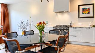 This stylish flat, measuring approximately 71 m², is situated on the second floor of the recently renovated ‘The Banker’ residential complex. The area around the Belgiëlei is a lively, up-and-coming neighbourhood, with attractions such as Stadsbrouwerij De Koninck, Het Pakt and the Groen Kwartier all within walking distance. What’s more, easy access is guaranteed thanks to the proximity of major access roads and public transport right on the doorstep.

You enter into the spacious living area with an open-plan fitted kitchen. The SMEG gas hob is undoubtedly a real eye-catcher here. The kitchen is also fitted with a dishwasher, fridge and freezer. There is a separate utility room with connections for a washing machine and tumble dryer.

Through the hall, you reach the bedroom situated at the quiet rear of the flat. It features a beautifully finished en-suite bathroom with a walk-in shower and washbasin. There is a separate guest toilet.

The communal garden is an oasis of tranquillity where you can relax and unwind.

A private cellar storage room and a space in the communal cycle shed are already included in the rent.

Service charges: 100 euros per month.
All utilities (gas, electricity and water) are to be taken privately by the tenant.

Available from 1 November 2026.
