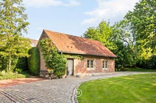 Hof ter Saele est situé sur un domaine historique de 52 ares qui faisait autrefois partie des biens féodaux de l’abbaye d’Affligem, avec une histoire de destruction et de reconstruction en 1643. La propriété est accessible par une allée de tilleuls majestueuse, avec un verger attenant d’arbres fruitiers. La maison dégage beaucoup de caractère grâce à des éléments authentiques tels que de hauts plafonds, des sols en pierre naturelle, des structures en poutres de chêne et des cheminées décoratives.<br /><br />La maison offre 488 m² habitables avec de beaux volumes.<br /><br />Au rez-de-chaussée, vous entrez par un hall d’entrée spacieux avec vestiaire et toilette invités. L’aile gauche donne accès à un bureau ou chambre d’amis pouvant servir de chambre supplémentaire, ainsi qu’à une buanderie avec raccordements. L’aile droite s’ouvre sur un séjour chaleureux avec cheminée, relié à la salle à manger et à la cuisine rénovée avec coin petit-déjeuner.<br /><br />À l’étage, un vaste hall de nuit avec placards intégrés et espaces de rangement. Trois chambres, dont une suite parentale avec salle de bain attenante avec baignoire et douche. Les deux autres chambres partagent une salle de bain.<br /><br />La propriété comprend un bâtiment annexe utilisé comme garage avec deux portes d’accès, espace pour deux voitures et rangement. Il dispose aussi d’un grenier pour stockage supplémentaire. Un second petit bâtiment sert de cabane de jardin. La maison est idéalement située sur l’axe Bruxelles–Gand, proche des commerces et écoles. Le jardin orienté plein sud, clôturé et sans vis-à-vis, offre calme et intimité.