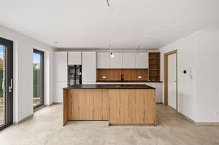 <p><span>Deze halfopen nieuwbouwwoning verrast op verscheidene fronten. Afgezien van de circa 6 meter diepe garage, is er op de 2 opritten nog plaats voor 2 auto's. In de gevel zijn zowel het portiek rond de voordeur als de lintelen boven de ramen, uitgevoerd in blauwe hardsteen. Het energetische doelpeil van E2 (Label A) werd onder meer bereikt door het voorzien van algemene vloerverwarming, warmtepomp, airco's (warmtepomp) in living en kamers, superisolerend glas, 12 zonnepanelen en ventilatiesysteem D. Qua stijlelementen spotten we een gevelsteen (recuperatielook) vermetst in wildverband, kleinhouten tussen de glasplaten, werkblad en trap in gehamerde natuursteen, glazen deur (living), etc.  De ruime leefruimte en greeploze keuken met eiland, kijken via verscheidene grote ramen uit op de tuin (gras) en het grote betegelde terras. Het kookvuur beschikt over centrale afzuiging. Voor het overige, stelen de volgende apparaten de show: combi-oven, oven, XL-koelkast en vaatwasser. De handige wasplaats/berging sluit aan op keuken én garage. In de badkamer beschikt u over een acrylbad, een breed dubbel houten meubel en een inloopdouche met regenfunctie en ingebouwde kranen. Buiten de drie kamers met airco waarvan één met dressing  staat nog de gehele tweede verdieping ter beschikking, als één grote kamer. In de nachthall en langsheen de trap, werkt de verlichting middels een bewegingsmelder. De Verbindingsstraat is een rustige woonstraat in een zone 30. Deze nieuwbouwwoning wordt verkocht onder een gemengd fiscaal stelsel, waarbij de grondwaarde onderworpen is aan 12% registratierechten en de constructiewaarde aan 21% btw.</span></p>