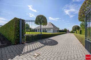 Deze charmante villa is uitstekend gelegen op een vlot bereikbare locatie, op korte afstand van het centrum van Oostmalle. Hier geniet u van een ideale combinatie van rust, ruimte en bereikbaarheid. Bovendien bestaat de mogelijkheid om de achtergelegen weilanden bijkomend aan te kopen.<br /><br />INDELING:<br /><br />Via de mooie oprit bereikt u de woning. Bij het binnenkomen wordt u verwelkomd in een ruime inkomhal. Rechts bevindt zich de lichtrijke leefruimte, die dankzij de vele raampartijen geniet van een aangename lichtinval en een prachtig uitzicht biedt op de fraai aangelegde tuin. Aansluitend bevindt zich de volledig uitgeruste keuken, die rechtstreeks toegang verleent tot het gezellige terras.<br /><br />Links van de inkomhal bevindt zich het slaapgedeelte. De woning beschikt over drie ruime slaapkamers en twee comfortabele badkamers. De eerste badkamer is uitgerust met een enkele lavabo, een ligbad en een toilet. De tweede badkamer beschikt over een dubbele lavabo en een inloopdouche. Via deze badkamer bereikt u bovendien een praktische bureauruimte, een wasplaats en een extra toilet.<br /><br />Verder beschikt de woning over een ruime bergzolder, wat zorgt voor extra opslagmogelijkheden.<br /><br />Buiten geniet u van een prachtig aangelegde, volledig omheinde tuin waar u in alle rust kunt ontspannen. Achter de afsluiting bevindt zich nog een extra perceelsgedeelte met een garage, een opslagplaats en een ruim magazijn. Deze bijkomende gebouwen bieden tal van mogelijkheden voor hobbyisten, zelfstandigen of wie op zoek is naar extra bergruimte.<br /><br />Kortom, een ruime en veelzijdige woning met een uitstekende ligging, ideaal voor gezinnen of wie wonen en werken wenst te combineren.<br /><br />BIJZONDERHEDEN: <br />- Goede bereikbare locatie<br />- Veel mogelijkheden <br />- Veel ruimte<br />- Aangelegde tuin<br /><br />Voor meer info of een bezoek ter plaatse kan u vrijblijvend contact opnemen met Lieselotte op 03.227.58.58 of lieselotte@reds.be.
