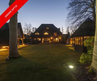 Stijlvolle villa op centrale locatie<br /><br />We treden dit schitterend perceel binnen via de automatische toegangspoort. Op de oprit is er plaats voor een scala aan wagens. Via de voordeur betreden we de villa via de inkomhal op authentieke tegels. Hier vinden we de trap naar boven, naar de grote kelder, de wasruimte en het gastentoilet met handenwasser. <br /><br />De oorspronkelijke deur verschaft ons toegang tot de ruime woonkamer, welke bestaat uit de eetkamer, bureauruimte en de zit- en tv kamer. Vanuit uit elke hoek van de woonkamer geniet men van prachtige zichten op de aangelegde tuin. De gezellige tv kamer beschikt over een inbouwcassette op hout. Aansluitend aan de eetkamer vinden we de gezellige keuken, met alle nodige toestellen. De ronde tafel is de perfecte plek voor elk gezin om samen de dag te beginen of af te ronden.<br /><br />Op de eerste verdieping vinden we 3 slaapkamers. De 2 ruime kinderkamers delen 1 badkamer, met douche en dubbele lavabo. De master slaapkamer heeft zijn eigen dressing, met ruim plaats voor alle kleren en schoenen. Naast de slaapkamer ligt de badkamer met ligbad, douche, dubbele lavabo en toilet.<br /><br />De bovenste verdieping is momenteel ingericht als bureau en gastenkamer, maar deze kamer kan makkelijk ingericht worden als volwaardige slaapkamer, met ernaast nog een kamer voor opslag.<br /><br />De tuin is compleet aangelegd met verschillende terrassen, hoekjes en plekjes om te spelen, te socializen, te eten, te ontspannen,… Er is zelfs een overdekte hottub. Verder vinden we ook nog een carport voor 1 wagen en een grote tuinberging. Heel de tuin is ’s nachts prachtig verlicht.<br /><br />De villa is gelegen in de wijk Donk, met alle nodige winkels, scholen, openbaar vervoer, snelweg… vlakbij.