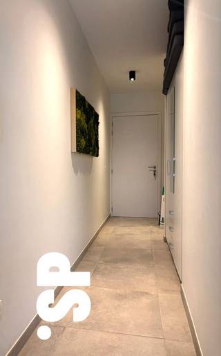 Men komt binnen in de inkomhal waar plaats is voorzien voor een vestiairekast. In de inkomhal is er tevens ook een gastentoilet aanwezig. Vanuit de inkomhal is er toegang tot de woonkamer met open keuken (tegels; 29m²). De keuken werd volledig geïnstalleerd met spoelbak, vaatwasser, kookvuur, dampkap, koelkast en combi-oven. De ruime wasplaats/berging grenst aan de keuken (tegels; 6m²). De woonkamer geeft toegang tot het ruime terras (tegels; 23m²) en de tuin. Verder beschikt het appartement over één slaapkamer (tegels; 12m²) en een ingerichte badkamer (tegels; 5m²) met een lavabomeubel en inloopdouche.<br /><br />Het appartement werd voorzien van lichtarmaturen en raamgarnituren. De tuin (oostelijk georiënteerd) is aangelegd.<br /><br />Bij het appartement hoort een ruime afgesloten kelderberging, één ondergrondse autostaanplaats en gemeenschappelijke fietsenberging, deze zijn inbegrepen in de huurprijs!<br /><br />- CV = aardgas (via vloerverwarming)<br />- E-peil < 40<br />- Zonnepanelen aanwezig!<br />- Huisdieren niet toegelaten.<br />- €60 algemene onkosten per maand<br /><br />Voor bijkomende inlichtingen of een bezoek ter plaatse kan u steeds vrijblijvend contact opnemen met Immo S|P via info@immosp.be