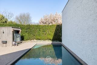 In een strategisch gelegen en uitstekend bereikbare woonomgeving in Grimbergen bevindt zich deze stijlvolle, hedendaagse villa met zwembad, waar comfort, luxe en energiezuinigheid naadloos samenkomen. Dankzij de uitstekende EPC-score A, ondersteund door zonnepanelen, een warmtepomp, vloerverwarming en een geavanceerd ventilatiesysteem, geniet u hier van duurzaam en toekomstgericht wonen met een uitzonderlijke afwerkingsgraad.<br /><br />Bij het betreden van de woning wordt u verwelkomd in een elegante inkomhal met aansluitend een praktisch bureel, ideaal voor wie wonen en werken wil combineren. De lichtrijke leefruimte met grote raampartijen en een sfeervolle open haard vormt het warme hart van de woning.<br /><br />De open, hyperuitgeruste keuken is een echte eyecatcher en werd afgewerkt met hoogwaardige materialen. Het natuurstenen kookeiland, de maatwerkkasten, de inloopkoelkast en de ingebouwde toestellen maken van deze ruimte een perfecte combinatie van esthetiek en functionaliteit.<br /><br />De villa telt vier ruime slaapkamers. De kinderkamers delen samen één badkamer, terwijl ook de gastenkamer over privatief sanitair beschikt. De masterbedroom beschikt over een dressing, wasruimte en ensuite badkamer met ligbad en inloopdouche. Een hobbyruimte vervolledigt het geheel. Buiten geniet u van een aangelegd terras met zwembad. Een dubbele garage, bergingen, parkeerplaats op de oprit en domotica zorgen voor extra comfort en functionaliteit.<br /><br />Deze woning biedt een harmonieuze combinatie van ruimte, luxe en technologie op een gegeerde locatie in Grimbergen.