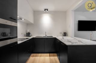 
Bent u op zoek naar een unieke woonplek die luxe, ruimte en een strategische ligging combineert? Dit nagenoeg nieuwe gelijkvloerse appartement uit 2021 biedt met zijn 98 m² aan bewoonbare oppervlakte een uitzonderlijke levenskwaliteit in het centrum van Sint-Antonius (Zoersel). De indeling is verrassend ruim en licht: een royale leefruimte met een moderne open keuken vormt het hart van de woning, geflankeerd door twee zeer grote slaapkamers die rust en privacy garanderen. Wat dit eigendom echter echt uniek maakt, is de veelzijdigheid. Dankzij de commerciële toplocatie aan de belangrijkste straat en de slimme indeling, leent dit pand zich namelijk perfect voor wie wonen en werken wil combineren of de ruimte volledig als handelszaak, kantoor of praktijkruimte wil aanwenden.

Op technisch vlak is dit appartement een absolute uitblinkster en volledig klaar voor de toekomst. Met een uitstekend EPC van 52 kWh/m² geniet u van een uiterst laag energieverbruik. Het pand is voorzien van de modernste technieken, waaronder een warmtepomp met vloerverwarming voor een heerlijk binnenklimaat, zonnepanelen voor groene energie, waterrecuperatie en een geavanceerd alarmsysteem. Alles is tot in de puntjes afgewerkt en volledig instapklaar, zodat u zonder zorgen kunt verhuizen. Het wooncomfort wordt verder vervolledigd door een private overdekte parkeerplaats en een uitzonderlijk grote kelderberging op de ondergrondse verdieping, wat een zeldzame luxe is in deze kern; deze zijn verplicht mee aan te kopen aan 25.000€.

Dit pand is de ideale match voor een breed publiek: van singles of koppels die op zoek zijn naar een ruim gelijkvloers appartement met alle voorzieningen op wandelafstand, tot ondernemers en vrije beroepers die hun zaak willen vestigen op een zichtlocatie zonder in te boeten op kwaliteit. Of u nu droomt van een riant appartement, een modern kantoor of een combinatie van beide, deze locatie biedt de flexibiliteit die u zoekt. Een buitenkans voor wie duurzaamheid en een centrale ligging hoog in het vaandel draagt.
