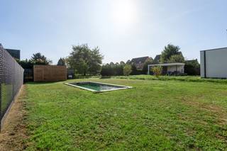 <p>Deze stijlvolle vrijstaande woning werd in 2024 gebouwd met bijzondere aandacht voor architectuur en hedendaags wooncomfort. Verscholen in het groene Noorderwijk, waar het gezellige dorpsleven en uitgestrekte landschappen hand in hand gaan, vind je hier alle ingrediënten voor een thuis waar rust en comfort de hoofdrol spelen.</p>
<p>Bij binnenkomst merk je meteen dat hier aan elk detail werd gedacht! Via een stijlvolle glazen deur stap je de zonovergoten leefruimte binnen. De royale raampartijen zorgen niet alleen voor licht en ruimte maar creëren ook een prachtige connectie met de tuin. Het zwembad vormt daarbij een absolute eyecatcher en geeft het buitenleven nét dat tikkeltje meer! Lange zomerdagen aan het water, gezellige avonden met vrienden vanop het gras of gewoon simpelweg helemaal tot rust komen in de tuin? Deze plek vormt het decor voor ontelbaar veel mooie herinneringen!</p>
<p>De trendy, open keuken werd ingericht met hoogwaardige materialen en kwaliteitsvolle toestellen, waarbij design en functionaliteit elkaar versterken. Verder ontdek je op het gelijkvloers nog een polyvalente kamer die zich perfect leent als bureau, hobbykamer of extra slaapkamer.</p>
<p>Via de houten trap bereik je de eerste verdieping, waar er nog maar liefst 4 riante slaapkamers op je wachten. Plek genoeg dus voor het hele gezin! Ook de badkamer is een plaatje op zich. De tegels in aardetinten zorgen voor een rustgevende luxueuze uitstraling, terwijl het comfortabel ligbad, de ruime inloopdouche en de dubbele lavabo in meubel zorgen voor een dosis welness in huis. Het toilet is apart.</p>
<p>Een eigen zwembad, een zee aan ruimte en een flinke dosis stijl. Klinkt als jouw droomwoning? Kom het zeker zelf eens ontdekken!</p>
<p><strong>Technische gegevens: EPC label A!! </strong>8 zonnepanelen aanwezig, regenwaterput van 5.000 liter. <strong>Tuinhuis voorzien. </strong></p>
<p><strong>Stedenbouwkundige inlichtingen en bodemattest aanwezig. Bevindt zich niet in een risicozone voor overstromingen (P- en G-score A). Renovatieverplichting en asbestattest niet van toepassing.</strong></p>