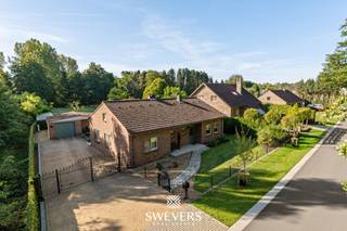 Voor meer info en foto’s, surf naar www.swevers.be – In een rustige, groene straat in het hart van Leopoldsburg ontdek je deze instapklare bungalow op een perceel van 42a 10ca. De woning is volledig gelijkvloers, gebouwd in 1989 en piekfijn onderhouden. Met een bewoonbare oppervlakte van 161 m², een ruime zolder van 128 m² en een droge kruipkelder biedt ze comfort en uitbreidingsmogelijkheden. De leefruimte van 32 m² baadt in natuurlijk licht en sluit aan op een open keuken van 24 m² met zicht op de zuidgerichte tuin. Verder zijn er drie slaapkamers (14 m², 12 m² en 6 m²), een badkamer met ligbad, douche en dubbele lavabo, en een praktische berging met toegang tot het terras. Buiten geniet je van een prachtig aangelegde tuin met een vrijstaande garage en ruime oprit. Alle dagelijkse voorzieningen vind je op amper 3 km afstand, met vlotte verbinding naar de autosnelweg. Voor meer informatie, bel 011 255 155. Bron bewoonbare oppervlakte: EPC – verslag.