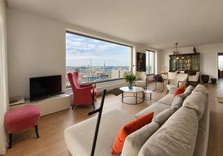 Dit luxueuze appartement bevindt zich op de elfde verdieping van een indrukwekkend gebouw aan de oever van het Kattendijkdok. Dankzij de unieke ligging geniet u langs drie zijden van een panoramisch uitzicht over Antwerpen, de Schelde, het Kattendijkdok en de jachthaven. Vanuit elke hoek ontdekt u een ander stukje van de stad.<br /><br />Het appartement heeft een royale oppervlakte van ca 135 m² en beschikt over een aangenaam, inpandig terras van ca. 17 m² met zuidoostelijke oriëntatie. De ruime leefruimte biedt een prachtig uitzicht en wordt gekenmerkt door een riante plafondhoogte en grote raampartijen, die zorgen voor een uitzonderlijk gevoel van ruimte en licht.<br /><br />Aansluitend bevindt zich de strakke, volledig uitgeruste keuken met een praktische berging met aansluitingen voor wasmachine en droogkast.<br /><br />De nachthal geeft toegang tot twee ruime slaapkamers. De masterbedroom biedt een zee van ruimte en ook de tweede slaapkamer is bijzonder aangenaam van oppervlakte. Beide slaapkamers beschikken over een eigen badkamer. De ene badkamer is uitgerust met een dubbele lavabo, ligbad met douchefunctie en toilet; de andere met een lavabo, douche en toilet.<br /><br />Een kelderberging op niveau -1 is reeds begrepen in de huurprijs.<br />Een autostaanplaats in de ondergrondse garage is bij te huren aan 150 Euro per maand.<br /><br />Gemeenschappelijke lasten: 200 Euro per maand.<br />Alle nutsvoorzieningen (verwarming, elektriciteit en water) zijn privé op te nemen door de huurder.<br /><br />Beschikbaar vanaf 1 oktober 2026.