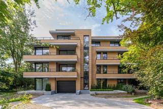 Sommige appartementen hebben dat fijne evenwicht tussen rust, licht en comfort. In Villa Le Prince komt dat mooi samen. Je woont er omringd door groen, terwijl Ekeren en Brasschaat vlakbij liggen.<br /><br />Het appartement bevindt zich op de eerste verdieping van een recent gebouw en valt meteen op door zijn lichtrijke leefruimte. De parketvloer zorgt voor warmte, de grote raampartijen halen het groen naar binnen en de open keuken vormt een mooi geheel met de leefruimte. Ze is volledig uitgerust met een grote kastenwand, geïntegreerde toestellen en een royaal kookeiland.<br /><br />Vanuit de leefruimte stap je zo het overdekte terras op. Beschut, omgeven door groen en een fijne plek om een groot deel van het jaar buiten te zitten.<br /><br />Dat hedendaagse wooncomfort merk je ook aan de energieprestaties. Met een uitzonderlijk laag E-peil van E8 woon je hier bijzonder energiezuinig. Bovendien geniet het appartement hierdoor van 2026 tot 2031 van 100% vrijstelling van de onroerende voorheffing. Een voordeel dat je niet alleen voelt in je wooncomfort, maar ook in je portemonnee.<br /><br />Verder zijn er twee ruime slaapkamers met maatkasten, een badkamer met inloopdouche en dubbel lavabomeubel, een apart toilet en een praktische berging met plaats voor wasmachine en droogkast.<br /><br />Ook praktisch zit het goed. Bij het appartement horen een privatieve kelderberging en een eigen autostaanplaats. Fietsen kunnen terecht in de gemeenschappelijke fietsenstalling en als bewoner geniet je bovendien van de ruime gemeenschappelijke tuin.<br /><br />Een appartement waar groen, licht en energiezuinig wonen vanzelf samenkomen, met alles wat je nodig hebt vlakbij.