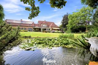 Deze stijlvolle villa bevindt zich op een uitzonderlijk perceel van bijna 3.000 m², op amper vijf minuten fietsen van het centrum van Meulebeke. Een eigendom waar architectuur, wooncomfort en duurzaamheid elkaar naadloos ontmoeten.<br /><br />De villa onderscheidt zich door haar sterke energetische prestaties, met onder meer 44 zonnepanelen, een laadpaal, een regenwatercapaciteit van 18.000 liter en een EPC dat nagenoeg label B behaalt. Praktische troeven zoals twee inpandige garageplaatsen, een ruime kelder met onder meer een wijnkelder en een kruipkelder benadrukken de uitzonderlijke kwaliteit en degelijkheid van deze woning.<br /><br />Wat deze eigendom bijzonder maakt, is haar veelzijdigheid. De doordachte indeling met twee afzonderlijke inkomdeuren biedt tal van mogelijkheden voor wie wonen en werken wil combineren, klanten in alle discretie wil ontvangen of op zoek is naar een oplossing voor kangoeroewonen of een zorgwoning.<br /><br />Binnen wordt u verwelkomd in een lichtrijk interieur waar ruimte, tijdloze architectuur en hoogwaardige afwerkingsmaterialen centraal staan. Grote raampartijen brengen het omliggende groen volledig tot leven en creëren een harmonieuze verbinding tussen binnen en buiten. <br /><br />Op het gelijkvloers vloeien de verschillende leefruimtes harmonieus in elkaar over. Een stijlvolle bureauruimte, een ruime woonkamer, een afzonderlijke tv-kamer en een lichtrijke veranda en de keuken geniet van een prachtig zicht op de tuin.<br /><br />De villa beschikt over vier volwaardige slaapkamers met maatwerkkasten en twee luxueuze marmeren badkamers, beide uitgerust met een ligbad en een inloopdouche.<br /><br />Ook buiten straalt deze eigendom rust en exclusiviteit uit. De fraai aangelegde tuin met beplanting, een strak onderhouden gazon en een sierlijke koivijver vormt een oase van privacy. De royale aanbouw fungeert als een volwaardige leefruimte die het hele jaar door een vloeiende overgang creëert tussen wonen en genieten van het buitenleven.<br /><br />Een uitzonderlijke residentie waar karakter, comfort en functionaliteit samenkomen op een toplocatie.<br /><br /><strong>Ook wild geworden van deze thuis?<br />Twijfel dan niet langer en leg vandaag nog uw bezoek vast!</strong>