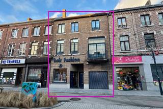 Deze knappe, instapklare stadswoning met een grote handelsruimte is gelegen in het hartje van Sint-Truiden, op wandelafstand van de Grote Markt en het station. Het pand werd volledig nieuw opgetrokken in 1994, met respect qua gevel en hoogte voor de omliggende herenwoningen. Het geheel werd opgericht met degelijke materialen, is steeds goed onderhouden, al kan het hier een daar een lichte opfrissing genieten. <br /><br />Zowel de woning als het handelsgedeelte beschikken over een aparte ingang in het overdekt portaal aan de straatzijde. Tevens hebben ze ieder een aparte elektriciteitsmeter. Hierdoor zouden beide delen autonoom van elkaar kunnen fungeren, mits het verkrijgen van de nodige toelatingen van het stadsbestuur.<br /><br />Het pand beschikt op het gelijkvloers over een grote handelsruimte van ca. 100m<sup>2</sup>, voorzien van een bijkeuken/wasplaats, alsook een apart gastentoilet en een extra buitenruimte. Momenteel is het geheel ingericht als kapsalon, voorzien van 6 kaptafels, 2 wastafels, een balie en een zit- en wachtruimte. Uiteraard kan dit handelsgedeelte ook voor andere doeleinden ingericht worden. Het pand zou eventueel als kangoeroewoning ingericht kunnen worden, mits toestemming van de gemeente.<br /><br />Het woongedeelte start eveneens op het gelijkvloers. We vinden er de inkomhal/traphal, een ruime garage, een CV-ruimte, en een rechtstreekse gang naar het handelspand. De eerste verdieping is ingedeeld met een leefruimte van ca. 42m<sup>2</sup> met balkon en knappe schouw, een grote leefkeuken, een apart gastentoilet en een slaapkamer/bureau, momenteel ingericht als TV-kamer, maar in te richten naar wens. In aansluiting van de leefkeuken is er een ruim terras dat deels afgesloten is en als veranda fungeert. De zijwand van de veranda, aan de kant van het open terras, kan open geschoven worden.<br /><br />Op de tweede verdieping vinden we een dressing-/bureauhoek (nog in te richten), drie ruime slaapkamers en een grote, ingerichte badkamer. De badkamer is voorzien van een ligbad, een douche, een toilet en een groot dubbel lavabomeubel. <br /><br />Nog meer ruimte nodig? De zolder, momenteel te bereiken via een vlizotrap, kan volledig ingericht worden als extra kamers of leefruimten. Elektriciteit werd hier reeds voorzien.<br /><br />Interesse in deze opportuniteit? Bel ons op 011 70 70 19 voor een afspraak ter plaatse.