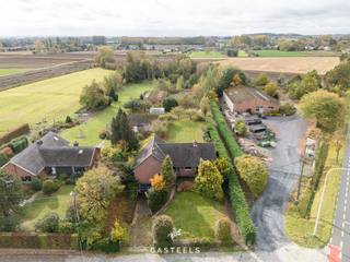 Op een perceel van maar liefst 5.643 m² bevindt zich deze vrijstaande te renoveren woning in Kruisem, deelgemeente van Gavere. Dankzij de zuidgerichte tuin, de grote oppervlakte én de vlotte bereikbaarheid richting N60, Gent en Oudenaarde, is dit een opportuniteit voor wie op zoek is naar ruimte en vrijheid met een centrale ligging.<br /><br /><u><strong>Indeling van de woning</strong></u><br />De bestaande woning heeft een bewoonbare oppervlakte van ca. 225 m² en biedt een klassieke, ruime indeling:
<ul>
	<li>Gelijkvloers: inkomhal, lichtrijke leefruimte, keuken, drie slaapkamers, een badkamer, bureauruimte en logeerkamer</li>
	<li>Verdieping: drie bijkomende kamers + grote zolderruimte met potentieel voor extra afwerking of berging</li>
	<li>Kelder &amp; Garage: inpandige garage met onderliggende kruipkelder</li>
	<li>Tuin: volledig zuidgericht, met mooi uitzicht op het achterliggende groen en volledige privacy</li>
	<li>Extra: op het perceel bevindt zich ook een ruime, aparte werkplaats of opslagruimte, ideaal voor zelfstandigen, hobbyisten of als bijkomende bergruimte.</li>
</ul>
<br /><u><strong>Stedenbouwkundige informatie – Zonevreemde woning</strong></u><br />Deze eigendom is gelegen in agrarisch gebied en wordt juridisch beschouwd als een zonevreemde woning. Er zijn geen verkavelingsvoorschriften, RUP of BPA van toepassing. Hierdoor gelden de basisrechten voor zonevreemde woningen zoals bepaald in art. 4.4.10 t.e.m. 4.4.19 van de VCRO:
<ul>
	<li>Verbouwen, herbouwen of uitbreiden is mogelijk met een maximum brutovolume van 1.000 m³</li>
	<li>Bij herbouw op dezelfde plaats is minstens 75% overlap vereist met de bestaande inplanting</li>
	<li>Bij herbouw op een andere plaats op het perceel gelden extra voorwaarden:
	<ul>
		<li>De aanvraag moet goed gemotiveerd zijn (betere integratie in de omgeving, efficiëntere terreinbezetting…)</li>
		<li>De nieuwe voorbouwlijn moet aansluiten bij deze van de naburige bebouwing of overeenstemmen met de courante inplantingswijze</li>
	</ul>
	</li>
	<li>Het aantal woonentiteiten mag niet vermeerderd worden</li>
	<li>Meergezinswoningen of tweede bouwlijn zijn niet toegestaan</li>
</ul>
<br /><u><strong>Unieke kans voor renovatie of heropbouw</strong></u><br />Deze eigendom biedt veel mogelijkheden voor wie op zoek is naar een woning met karakter, ruimte en herontwikkelingspotentieel. Of u nu kiest voor een volledige renovatie of een nieuwbouwproject binnen het toegestane volume: de combinatie van ligging, bereikbaarheid, perceeloppervlakte en oriëntatie is zeldzaam.<br /><br />Mis deze kans niet en contacteer ons voor meer informatie, documenten, plannen of om een bezoek in te plannen.