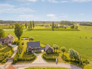 Deze hoogwaardig afgewerkte nieuwbouwwoning, te koop onder het gunstige stelsel van registratierechten, ligt op een uitstekend bereikbare en toch zeer groene locatie in Hansbeke. Het zorgvuldig aangelegde perceel vormt een natuurlijk verlengstuk van de woning en biedt een prachtig, rustgevend panorama over de omliggende natuur.<br /><br />Bij binnenkomst verwelkomt de ruime inkomhal met gastentoilet u en zet meteen de toon voor de rest van het huis. De open leefkeuken met kwaliteitsvolle toestellen vormt het hart van de woning en sluit naadloos aan op de eetplaats en leefruimtes. Dankzij de grote raampartijen, volledig georiënteerd op de tuin, vloeien binnen- en buitenleven harmonieus in elkaar over. De leefruimtes zijn voorzien van vloerverwarming voor optimaal comfort. Aansluitend bevindt zich een praktische wasplaats met extra bergruimte en buitendeur.<br /><br />Op de eerste verdieping vindt u drie volwaardige slaapkamers en twee badkamers. De master bedroom biedt luxe met een eigen dressing en ensuite badkamer. De twee overige slaapkamers delen een tweede, ruime badkamer met ligbad.<br /><br />De hoger gelegen verdieping herbergt een riante, multifunctionele ruimte die kan dienen als extra slaapkamer, kantoor of hobbyruimte.<br /><br />Naast de woning staat een kwalitatief afgewerkte garage, momenteel ingericht als inspirerend thuiskantoor. Deze eigendom staat garant voor een doordachte indeling en uitzonderlijke afwerking.<br /><br />Meer info en 3D-tour op www.hillewaere-vastgoed.be