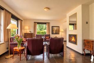 <p><strong>Deze ruime en zeer goed onderhouden villa is ideaal gelegen op een zuidgeoriënteerd perceel van ca. 1.705 m², in een rustige, groene en kindvriendelijke villawijk te Retie. De woning biedt verrassend veel ruimte en beschikt onder andere over 6 slaapkamers, 2 badkamers, een lichtrijke leefruimte en heel wat praktische bergruimte. Ook buiten is het aangenaam vertoeven dankzij de zuidgerichte tuin, het terras en de gezellige tuinkamer met open haard. De ligging vormt een bijkomende troef: bossen en talrijke fiets- en wandelroutes bevinden zich in de onmiddellijke omgeving, terwijl Retie, Postel, Dessel en Nederland op korte afstand gelegen zijn.<br /><br /></strong><span>Gelijkvloerse verdieping</span>: <span>Via de inkomhal betreedt u de woning. Rechts bevinden zich een vestiaire en een apart gastentoilet. Links geeft een deur toegang tot de ruime en lichtrijke woonkamer, die dankzij de grote raampartijen geniet van veel natuurlijk daglicht en een mooi zicht op de tuin. De leefruimte is opgedeeld in een gezellige zithoek met open haard en een eetkamer.<br /><br /></span><span>Aansluitend bevindt zich de keuken, uitgerust met een oven, elektrisch kookvuur en veel kastruimte. Naast de keuken ligt een praktische bijkeuken met ingemaakte kasten, aansluitingen voor wasapparatuur en vaatwasser en een achterdeur die rechtstreeks toegang geeft tot de tuin.<br /><br /></span><span>Via de nachthal bereikt u een eerste badkamer met douche, wastafel en toilet, een dressing en drie slaapkamers, waarvan één momenteel ingericht is als bureau en voorzien is van ingemaakte kasten. Ook één van de andere slaapkamers beschikt over ingemaakte kasten en een wastafel.<br /><br /><span>Verdieping:</span> Vanuit de inkomhal leidt de trap naar de verdieping. Hier bevinden zich nog eens drie ruime slaapkamers, waarvan twee voorzien zijn van ingemaakte kasten en een wastafel. Daarnaast is er een tweede badkamer met ligbad en douche en een apart toilet. De nachthal beschikt eveneens over praktische ingemaakte kasten. Een bijkomende troef is de bijzonder ruime opbergmogelijkheid: de schuine wanden over nagenoeg de volledige verdieping werden ingericht als bergruimte.<br /><br /><span>Buitengebeuren:</span> De woning beschikt over een aangename, zuidgerichte tuin met terras. Aansluitend aan de woning bevindt zich een gezellige tuinkamer / overdekt terras met open haard, waardoor u ook tijdens koelere momenten optimaal van de tuin kunt genieten. De tuin is achteraan volledig omheind en biedt veel rust en privacy.<br /><br />Naast de tuinkamer bevindt zich nog een praktische berging met spoelbak en technische ruimte. Aan de woning is tevens een overdekte carport voorzien, met in het verlengde een royale fietsenberging/werkplaats die heel wat extra praktische ruimte biedt. Vooraan beschikt de woning over een oprit met ruime parkeergelegenheid.<br /><br /><span>Bijzonderheden:</span> <br />- B</span>ouwjaar: 1988<br />- Centrale verwarming op aardgas via radiatoren<br />- Veluxramen voorzien van rolluiken<br />- Houten schrijnwerk<br />- Vliegenramen<br />- Kruipruimte onder de volledige woning<br />- Veel ingemaakte kasten en bergruimte<br />- Overdekte carport<br />- Rustige en kindvriendelijke villawijk<br />- Groene ligging nabij bossen en diverse fiets- en wandelroutes</p>
