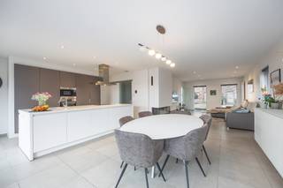 Deze <strong>recent gebouwde halfopen woning (2018)</strong> verkeert in <strong>uitstekende staat </strong>en combineert<strong> ruimte, comfort en hedendaagse afwerking.</strong><br />De woning is gelegen op een perceel van <strong>230 m²</strong> en beschikt over een <strong>bewoonbare oppervlakte van ca. 180 m².</strong> Bij het betreden van de woning komt u terecht in <strong>een ruime en lichtrijke leefruimte,</strong> waar de <strong>gashaard</strong> zorgt voor <strong>extra sfeer en gezelligheid</strong>. De <strong>open keuken</strong> is <strong>volledig uitgerust</strong> met alle <strong>hedendaagse toestellen</strong> en afgewerkt met een <strong>kwalitatief natuurstenen werkblad</strong>. Aansluitend bevindt zich een <strong>praktische en ruime berging</strong> met plaats voor <strong>wasmachine, droogkast en extra stockage.</strong><br /><br />Op de verdieping bevinden zich <strong>drie royale slaapkamers</strong>, waarvan <strong>één slaapkamer is voorzien van een inloopdressing</strong>. <strong>De badkamer</strong> is <strong>comfortabel</strong> ingericht met zowel een <strong>ligbad als een inloopdouche</strong>. Daarnaast is er zowel op het gelijkvloers als op de verdieping een <strong>apart toilet</strong>, wat het wooncomfort extra verhoogt.<br />Verder beschikt de woning over <strong>een ruime zolder</strong>, ideaal als extra bergruimte. Buiten geniet u van een onderhoudsvriendelijke tuin aangelegd met <strong>kwalitatief kunstgras</strong>, een <strong>praktisch tuinhuis</strong> en een <strong>voortuin met privatieve parkeerplaats.</strong><br /><br />Deze instapklare woning wordt aangeboden met een <strong>startprijs van €450.000</strong>. Bezoeken zullen georganiseerd worden via twee bezoekmomenten, namelijk op zaterdag <strong>28 februari en zaterdag 7 maart</strong>. Graag aanwezig op dit moment? Bel ons gerust op. <br /><br />Dankzij het recente bouwjaar, de hoogwaardige afwerking en de instapklare staat is deze woning uitermate geschikt voor wie zorgeloos en comfortabel wil wonen.