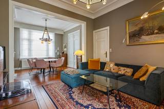 Deze super charmante, instapklare woning is gelegen in een aangename, residentiële wijk in het centrum van Ekeren. Winkels, scholen en het openbaar vervoer zijn allemaal in de nabije omgeving terug te vinden. Bovendien bevindt u zich hier vlakbij de oprit van de snelweg en het centrum van Antwerpen. Ook natuurgebied De Oude Landen is op wandelafstand te bereiken. De woning werd de afgelopen jaren gerenoveerd met oog voor authentieke details en is absoluut een pareltje. Binnenkomen doet u hier via een inkomhal op tegelvloer, waar hoge plafonds en knappe muur- en plafondornamenten meteen in het oog springen. De ruime  woonkamer heeft een mooie parketvloer en geniet dankzij een groot raam vooraan van heel wat lichtinval. Let ook hier zeker op de hoge plafonds, authentieke deuren en natuurstenen haarden, waardoor de ruimte heel wat cachet uitstraalt. De keuken met knusse ontbijthoek werd vernieuwd in 2018 en beschikt over alle comfort. Tussen de leefruimte en de keuken bevindt zich nog een polyvalente ruimte op tegelvloer, welke werd gebruikt als winkelruimte/atelier. Echter zou deze prima toegevoegd kunnen worden aan de leefkeuken of kunnen dienen als extra zithoek, speelkamer, hobbyruimte,... Grote uitslaande ramen en een lichtkoepel trekken opnieuw heel wat daglicht naar binnen. Verder is op het gelijkvloers nog een berging met gastentoilet aanwezig. Een houten trap leidt naar de bovenverdieping. Op de tussenverdieping bevinden zich een ruime dressing en een nette badkamer met ligbad, douche, toilet en dubbele wastafel met meubel. De 1e verdieping telt 2 ruime slaapkamers en een bureau. Ook de 2e verdieping is te bereiken via de vast trap. U vindt hier nog 2 volwaardige slaapkamers, waarvan 1 met open vide op de 3e verdieping. De woning beschikt verder nog over een droge kelder, dewelke heel wat extra opbergruimte biedt. Het perceel heeft een totale oppervlakte van 315m².  In de bijzonder gezellige, oostelijk georiënteerde tuin met aangelegd terras en tuinberging kan u in alle rust en privacy van de buitenlucht genieten.