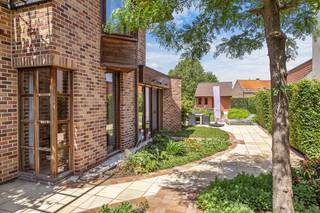 Op een uitstekende ligging langs een belangrijke invalsweg naar Kuurne bevindt zich deze ruime handelswoning met praktijkruimte en prachtig aangelegde zuidwestgerichte tuin. Dankzij de combinatie van wonen en werken onder één dak is dit eigendom ideaal voor zelfstandigen, vrije beroepen of als kangoeroewoning.<br />De woning heeft eveneens een afzonderlijke inkom en biedt een ruime lichtrijke leefruimte met volledig ingerichte keuken, eetplaats en salon. Verder zijn er een kelder, praktische berging en directe toegang tot de verzorgde tuin met vijver en meerdere zonneterrassen.<br />Op de verdieping bevinden zich vier ruime slaapkamers, een badkamer met bad en douche, een apart toilet en een technische ruimte. De grote zolder biedt extra opslagmogelijkheden.<br />Achteraan het perceel bevindt zich een ruime garage met plaats voor een wagen, fietsen en extra bergruimte.<br />De praktijkruimte beschikt over een aparte ingang, wachtzaal, bureel- of winkelruimte, drie ruime kamers en een rolstoeltoegankelijk toilet.<br />Deze eigendom werd afgewerkt met duurzame en kwalitatieve materialen zoals padoek ramen, koperen goten, massieve deuren en maatwerkkasten.<br /><u><strong>Troeven</strong></u><br />✔ Combinatie wonen en werken<br />✔ Mogelijkheid tot kangoeroewoning<br />✔ 4 slaapkamers<br />✔ Aparte toegang voor praktijkruimte<br />✔ Zuidwestgerichte tuin met vijver<br />✔ Ruime garage en grote zolder<br />✔ Hoogwaardige afwerking<br />✔ Strategische en commerciële ligging<br />
<p> </p>