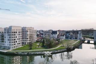 Dit ruime en kwalitatief afgewerkte appartement van 99 m² met een terras van 15 m² maakt deel uit van het recente nieuwbouwproject Liv De Molens, gelegen op een centrale maar rustige locatie in Deinze. Het project bevindt zich langs de oevers van de Leie en biedt een aangenaam uitzicht over het water en het toekomstige stadspark, dat zal uitgroeien tot een groene ontmoetingsplaats voor bewoners en bezoekers.<br /><br /><strong>Ligging en omgeving</strong><br />De stad Deinze biedt een evenwicht tussen stedelijk comfort en een groene, aangename woonomgeving. Winkels, scholen, openbaar vervoer en recreatiefaciliteiten bevinden zich op wandel- en fietsafstand. Dankzij de nabijheid van de E17 en het treinstation is er een vlotte verbinding met Gent, Kortrijk en de rest van de Leiestreek.<br /><br /><strong>Indeling en afwerking</strong><br />Het appartement omvat twee slaapkamers en een lichtrijke leefruimte met open keuken. De grote raampartijen zorgen voor een overvloed aan natuurlijk licht en bieden een rechtstreeks zicht op de Leie. Het westelijk georiënteerd terras heeft een oppervlakte van 15 m². De afwerking is van hoog niveau, met onder meer vloerverwarming, parketvloeren en duurzame materialen die bijdragen aan een aangenaam en energie-efficiënt wooncomfort. Dankzij de doordachte indeling en het moderne interieur is dit appartement geschikt voor zowel eigen bewoning als investering.<br /><br /><strong>Parkeerplaats en berging</strong><br />Naast de ondergrondse berging die is inbegrepen in de prijs, kan er ook een ondergrondse staanplaats worden aangekocht aan de prijs van 35.000 euro. <br /><br /><strong>Project Liv De Molens</strong><br />Liv De Molens is een hedendaags en duurzaam nieuwbouwproject dat uitblinkt in architecturale kwaliteit en wooncomfort. De gemeenschappelijke delen zijn met zorg aangelegd en sluiten harmonieus aan op de groene omgeving langs het water.<br /><br />Het appartement is momenteel verhuurd aan €950 per maand, exclusief €80 provisie, wat het tot een interessante investeringsopportuniteit maakt met onmiddellijk rendement. Indien de koper het pand zelf wenst te betrekken, dient rekening te worden gehouden met de wettelijke opzegtermijnen.<br /><br />De verkoop vindt plaats onder het tarief van 2% registratierechten bij aankoop als enige en eigen woning, of 12% voor investeringsdoeleinden.<br /><br />Epeil 22 / elektriciteit conform / centrale verwarming op aardgas <br /><br />Meer info kunt u vrijblijvend bekomen via 09 278 78 79 of guillian@landbergh.be