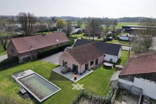 Deze woning van ca. 411 m² bevindt zich op een aantrekkelijke locatie op wandelafstand van de dorpskern van Vosselare. Ze werd volledig geïsoleerd en uitgerust met een lucht/waterwarmtepomp in combinatie met een zonneboiler voor vloerverwarming en warm water. 30 zonnepanelen ondersteunen een duurzaam energieverbruik, terwijl een lucht/luchtwarmtepomp zorgt voor comfortabele koeling in de slaapkamers. Op het gelijkvloers vindt u een inkomhal met gastentoilet en bureauruimte, een leefruimte met open nok die het gevoel van ruimte versterkt, en een volledig uitgeruste keuken met inbouwtoestellen en plaats voor een eetruimte. De keuken sluit aan op een praktische berging, terwijl een tweede inkom toegang biedt tot de was- en strijkruimte. Verder zijn er drie volwaardige slaapkamers, waaronder één met dressing, en een quasi volledig afgewerkte badkamer met dubbele lavabo, ligbad, inloopdouche en toilet. De eerste verdieping biedt twee grote slaapkamers en een vide, ideaal voor een bureau, hobbyruimte of extra leefruimte. De tweede badkamer is voorbereid voor verdere afwerking en er is een apart tweede toilet aanwezig. De tuin beschikt over zonneterrassen, een zwemvijver en een oprit met meerdere plaatsen. <br />​​​​​​<br />EPC: 66kWh (A) / elektriciteit: Conform / CV warmtepomp/ asbestveilig<br /> 