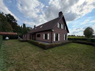 Deze ruime vrijstaande woning is gelegen aan de Hazelarenhoek in Assenede en combineert een landelijk karakter met bijzonder veel woon- en bergruimte. Met een bewoonbare oppervlakte van maar liefst 242 m², een dubbele inpandige garage en verschillende volwaardige ruimtes biedt de woning een uitstekende basis voor wie comfortabel en ruim wil wonen.<br /><br />Op het gelijkvloers komt u binnen in een aangename en lichtrijke leefruimte, waar de vele raampartijen en de karaktervolle haard meteen voor een warme sfeer zorgen. Aansluitend bevindt zich de ruime keuken, voorzien van heel wat werk- en kastruimte. Verder beschikt deze verdieping over een slaapkamer en badkamer, waardoor gelijkvloers wonen perfect mogelijk is. Een bijkomende praktische ruimte geeft rechtstreeks toegang tot de tuin.<br /><br />Een absolute troef is de uitzonderlijk ruime dubbele inpandige garage. Naast plaats voor twee wagens is hier nog volop ruimte voor fietsen, stockage of een werkhoek. Daarnaast is er op het terrein nog een afzonderlijke garage aanwezig, wat de woning bijzonder interessant maakt voor wie veel bergruimte zoekt.<br /><br />Ook op de verdieping verrast de woning met haar ruimte. Hier bevinden zich meerdere kamers die flexibel kunnen worden ingericht als slaapkamer, bureau, hobbyruimte of dressing. Daarnaast is er een tweede badkamer met ligbad. De houten afwerking onder het hellende dak zorgt hier voor een warm en karaktervol geheel.<br /><br />Rondom de woning ligt een verzorgde tuin met een groen en landelijk karakter. De ruime oprit zorgt bovendien voor voldoende parkeermogelijkheden op eigen terrein. Dankzij de rustige ligging geniet u hier van de nodige privacy en ruimte, terwijl het centrum van Assenede en de belangrijkste verbindingswegen vlot bereikbaar blijven.<br /><br />Ook energetisch beschikt de woning over een mooie basis, met een EPC-score van 184 kWh/(m² jaar). In combinatie met de royale bewoonbare oppervlakte, de mogelijkheid tot gelijkvloers wonen, de vele multifunctionele ruimtes en maar liefst drie garageplaatsen is dit een bijzonder complete woning voor wie ruimte en praktisch wooncomfort weet te waarderen.<br /><br />Beschikbaar vanaf 01/11/2026.<br /><br />Meer informatie of deze woning zelf ontdekken? Neem gerust contact op met Louis Van Zele van Immo Francois Meetjesland voor een bezoek ter plaatse.<br /><br />