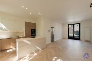 <p><span>Apartment Information</span></p><p><span>Located on a quiet, tree-lined one-way street, within walking distance of Marnixplaats, the KMSKA, restaurants, and coffee shops, is this luxuriously renovated apartment. The combination of a prime location, high-quality finishes, and the comfort of a new-construction home makes this an exceptional living opportunity in Antwerp South. </span></p><p><span> </span></p><p><span>The apartment was finished with an eye for detail using timeless materials such as travertine, light oak, herringbone parquet, and custom-made elements. The elegant entry hall with built-in closets leads to a light-filled living space with high ceilings, a spacious seating area, a full-sized dining area, and elegant wall cabinets. The open kitchen flows seamlessly into this space and features travertine finishes, high-end appliances, and a luxurious, natural aesthetic.</span></p><p><span> </span></p><p><span>From the living area, you have access to a pleasant outdoor space of approximately 19 m²: a rare asset in this location. </span></p><p><span> </span></p><p><span>The night hall leads to two spacious bedrooms, both with an en-suite bathroom featuring a walk-in shower and a designer vanity unit. The top floor offers a versatile attic room with air conditioning. </span></p><p><span> </span></p><p><span>This small-scale building, with only three apartments, has been completely renovated and will be completed in 2026 in compliance with EPB standards. EPC rating A, electricity system compliant at closing, individual meters, and low monthly costs.</span></p><p><span> </span></p><p><span> Live in a home with the look and performance of a new build, VAT-exempt, in one of Antwerp’s most sought-after locations.<br /><br /></span></p><p><span>Layout</span></p><p><span>Second floor</span></p><p><span>Upon entering the apartment, you step into an elegant entry hall with built-in custom cabinets, which immediately sets the tone for the rest of the home. There is a separate guest restroom with a hand sink.</span></p><p><span> </span></p><p><span>The living area forms the heart of the apartment: a particularly pleasant and light-filled living room with high ceilings, herringbone parquet flooring, and stylish custom finishes. The space easily accommodates a comfortable seating area with a spacious sofa, a full-sized dining area for a large table, and additional storage space thanks to the built-in closets and a sophisticated wall cabinet. The living area opens onto the outdoor space, consisting of a 10m² terrace and a 9m² green roof. This outdoor space serves as a rare and exceptionally pleasant extension of the living area: ideal for an aperitif, a quiet morning coffee, or an intimate al fresco dinner.</span></p><p><span> </span></p><p><span>The open kitchen flows seamlessly into the living area and is finished with luxurious travertine. It is fully equipped with high-quality appliances, including an induction cooktop, range hood, dishwasher, convection oven, microwave, refrigerator, and freezer. The combination of natural materials and modern functionality creates a timeless, elegant look.</span></p><p><span> </span></p><p><span>Third Floor</span></p><p><span>The night hall provides access to two spacious bedrooms, each equipped with built-in closets and its own en suite bathroom. Both bathrooms feature a walk-in shower and a travertine sink, ensuring a particularly high-quality and uniform finish.</span></p><p><span> </span></p><p><span>This floor also features a separate toilet. Under the stairs leading to the attic, there is a practical connection for a washing machine and/or dryer, subtly integrated without compromising aesthetics.</span></p><p><span> </span></p><p><span>Fourth Floor</span></p><p><span>The top floor houses a spacious, air-conditioned attic room. This versatile space is perfect as a master suite, home office, guest room, or hobby room. Thanks to its separate location, this floor offers an extra sense of privacy and comfort.</span></p><p><span> </span></p><p><span>Highlights</span></p><p><span>This apartment stands out for its high-quality finishes and exceptional renovation standards. The combination of travertine, light oak, herringbone parquet, custom-made features, and high ceilings creates a timeless, luxurious ambiance.</span></p><p><span> </span></p><p><span>Additional perks include built-in closets, a spacious terrace, the option to purchase an additional storage unit, and low monthly expenses, estimated at approximately 25 euros per month.</span></p><p><span> </span></p><p><span>General Information</span></p><p><span>The apartment has individual meters for gas, water, and electricity. Thanks to the thorough renovation, it has an EPC rating of A. The electrical inspection report will be provided with the deed. The asbestos certificate is currently pending.</span></p><p><span> </span></p><p><span>The buyer’s share of the cost for drafting the basic deed is 1,000 euros, including VAT.</span></p><p><span> </span></p><p><span>The Building</span></p><p><span>This small-scale building consists of a basement and only three apartments. It has been completely renovated and will be delivered in 2026 in compliance with EPB standards. Among other things, the ventilation system was replaced, the roof structure was renovated and insulated, a green roof was installed, the front and rear facades were insulated, and new exterior window and door frames were installed.</span></p><p><span> </span></p><p><span>So, you are essentially purchasing an apartment with the comfort and technical performance of a new construction, without having to pay VAT.</span></p><p><span> </span></p><p><span>The building also features a central smoke detection system and a videophone. There is no elevator.</span></p><p><span> </span></p><p><span>Location</span></p><p><span>The location is undoubtedly one of its greatest assets. The apartment is situated on a quiet, tree-lined one-way street, in a prime location in Antwerp, close to Marnixplaats in the Zuid district.</span></p><p><span> </span></p><p><span>Restaurants, coffee bars, cozy cafés, boutiques, concept stores, and the renovated KMSKA are all within walking distance. At the same time, you’ll enjoy easy access to the Antwerp ring road.</span></p><p><span> </span></p><p><span>With a Mobiscore of 9.6/10, this is the ideal place for anyone who wants to live comfortably, stylishly, and in an urban setting in one of Antwerp’s most sought-after locations.</span></p><p><span> </span></p><p><span>Viewing Day: July 11</span></p><p><span>Interested candidates may submit an offer, after which the seller will thoroughly and carefully review each offer.</span></p><p><span>The real estate agency will notify candidates of the decision or next steps no later than 3 days after the open house.</span></p><p><span> </span></p><p><span> *The information in this brochure is provided for informational purposes only: prospective buyers are responsible for obtaining, verifying, and interpreting this information on their own.</span></p>