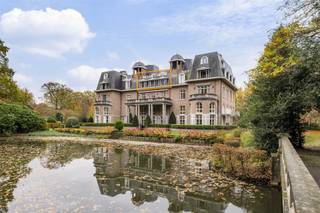 <p><span>Spacious castle apartment located in a unique location in the middle of the quiet park domain ‘Blauwhof’, near the center of Kapellen! The apartment includes an entrance hall, spacious living room with sunny terrace, dining room with enclosed terrace, separate kitchen, 2 bedrooms, 2 fitted bathrooms and 2 underground car parking spaces.</span></p><p><span> </span></p><p><span>LAYOUT</span></p><p><span> </span></p><p><span>Ground floor</span></p><p><span>The elevator takes you directly to the apartment. You enter a spacious entrance hall on epoxy floor, equipped with a guest toilet and checkroom. From the entrance hall you have access to the separate kitchen on epoxy floor, equipped with a stove hood, teppanyaki, built-in coffee machine, dishwasher, combi-oven/microwave, separate microwave, double fridge and sink.</span></p><p><span>Adjacent is a practical laundry room with ample storage cabinets and plumbing for a washer and dryer.</span></p><p><span>The dining room on parquet floor is accessible from the entrance hall and has an enclosed terrace and a useful storage cupboard.</span></p><p><span>A passage on parquet floor, with built-in closets, leads to the first bedroom on parquet floor, with built-in closets and a fully equipped bathroom on tiled floor, equipped with a bath, shower, double sink and toilet.</span></p><p><span>The second bedroom on parquet floor has an ensuite bathroom on tiled floor, equipped with a shower, single sink and toilet.</span></p><p><span> </span></p><p><span>Second floor </span></p><p><span>Through the wooden spiral staircase or by elevator you reach the second floor. Here there is a spacious and bright sitting area on parquet floor, with a cozy wood fireplace and a small kitchenette. From this room you have access to the sunny terrace with beautiful views of the greenery and the beautifully landscaped pond. </span></p><p><span> </span></p><p><span>Garage</span></p><p><span>The apartment has two underground car parking spaces: one enclosed garage box (mandatory to buy along for € 25,000) and one between lines (optional to buy along for € 25,000)</span></p><p><span> </span></p><p><span>Details</span></p><p><span>- Located in a coveted location: in a beautiful park domain ‘Blauwhof’ of 108.076 m², near the center of Kapellen and various amenities (restaurants, stores, schools, public transport,...). </span></p><p><span>- Living in a unique and classy castle.</span></p><p><span>- Elevator goes directly into the apartment (both ground and second floor).</span></p><p><span>- Spacious, sunny terrace with magnificent view of the greenery and the pond.</span></p><p><span>- The apartment has two underground parking spaces: one enclosed garage box (mandatory to buy along for € 25,000) and one between lines (optional to buy along for € 25,000).</span></p><p><span> </span></p><p><span> </span></p>