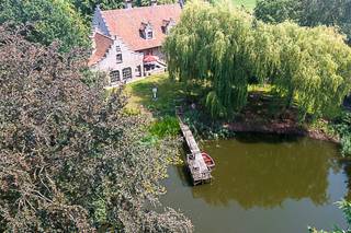 Er zijn plaatsen die veel meer zijn dan een woning. <strong>Ze vormen een bestemming op zich</strong>. Welkom op <strong>Landgoed Lindenhof</strong>, een uitzonderlijk privélandgoed waar rust, natuur en tijdloze elegantie elkaar ontmoeten.<br /><br />Verborgen achter een statige oprijlaan ontvouwt zich een prachtig aangelegd domein waar majestueuze bomen, uitgestrekte graspartijen en een indrukwekkende natuurlijke vijver samen een uitzonderlijk decor vormen. Verschillende terrassen en sfeervolle plekjes nodigen uit om op elk moment van de dag te genieten van de rust en de schoonheid van het landschap. Hier wordt het buitenleven een vanzelfsprekend onderdeel van elke dag en maakt de drukte van het dagelijkse leven plaats voor stilte, ruimte en ontspanning.<br /><br />Ook binnen ademt de villa dezelfde warme authenticiteit. De statige inkomhal met gastentoilet verwelkomt u in een interieur waar massieve eiken balken, natuurstenen vloeren, karaktervolle haarden en verfijnd maatwerk samen een tijdloze elegantie creëren. De royale leefruimtes bieden een prachtig uitzicht op het omliggende groen, terwijl de landelijke leefkeuken uitnodigt tot lange avonden met familie en vrienden.<br /><br />De hoofdwoning beschikt over <strong>vijf volwaardige slaapkamers</strong>, waarvan één slaapkamer op het gelijkvloers, ideaal als bureau of gastenkamer. Op de eerste verdieping bevinden zich nog <strong>vier ruime slaapkamers</strong> en twee stijlvolle badkamers, waardoor de villa perfect aansluit bij grotere gezinnen of wie graag gasten ontvangt.<br /><br />Een absolute troef van <strong>Landgoed Lindenhof</strong> is het afzonderlijke gastenverblijf met een gezellige leefruimte en bar op het gelijkvloers en een slaapkamer op de verdieping. Deze veelzijdige ruimte biedt tal van mogelijkheden als gastenverblijf, ontspanningsruimte, praktijk aan huis of verblijf voor inwonende familie. Daarnaast beschikt het domein over een ruime werkplaats met garage, ideaal voor zelfstandigen, hobbyisten of het veilig stallen van voertuigen en materiaal.<br /><strong>Landgoed Lindenhof is meer dan een exclusieve villa</strong>. Het is een plek waar natuur, architectuur en levenskwaliteit elkaar ontmoeten. Een eigendom die uitnodigt om te onthaasten, te genieten en elke dag opnieuw de rust van een uitzonderlijk privélandgoed te ervaren.<br /><br /><strong>Ontdek Landgoed Lindenhof</strong><br />De ware schoonheid van Landgoed Lindenhof openbaart zich pas wanneer u het domein zelf ervaart. Contacteer ons voor een exclusieve rondleiding en ontdek de unieke harmonie tussen architectuur, natuur en levenskwaliteit die Landgoed Lindenhof zo bijzonder maakt.<br />